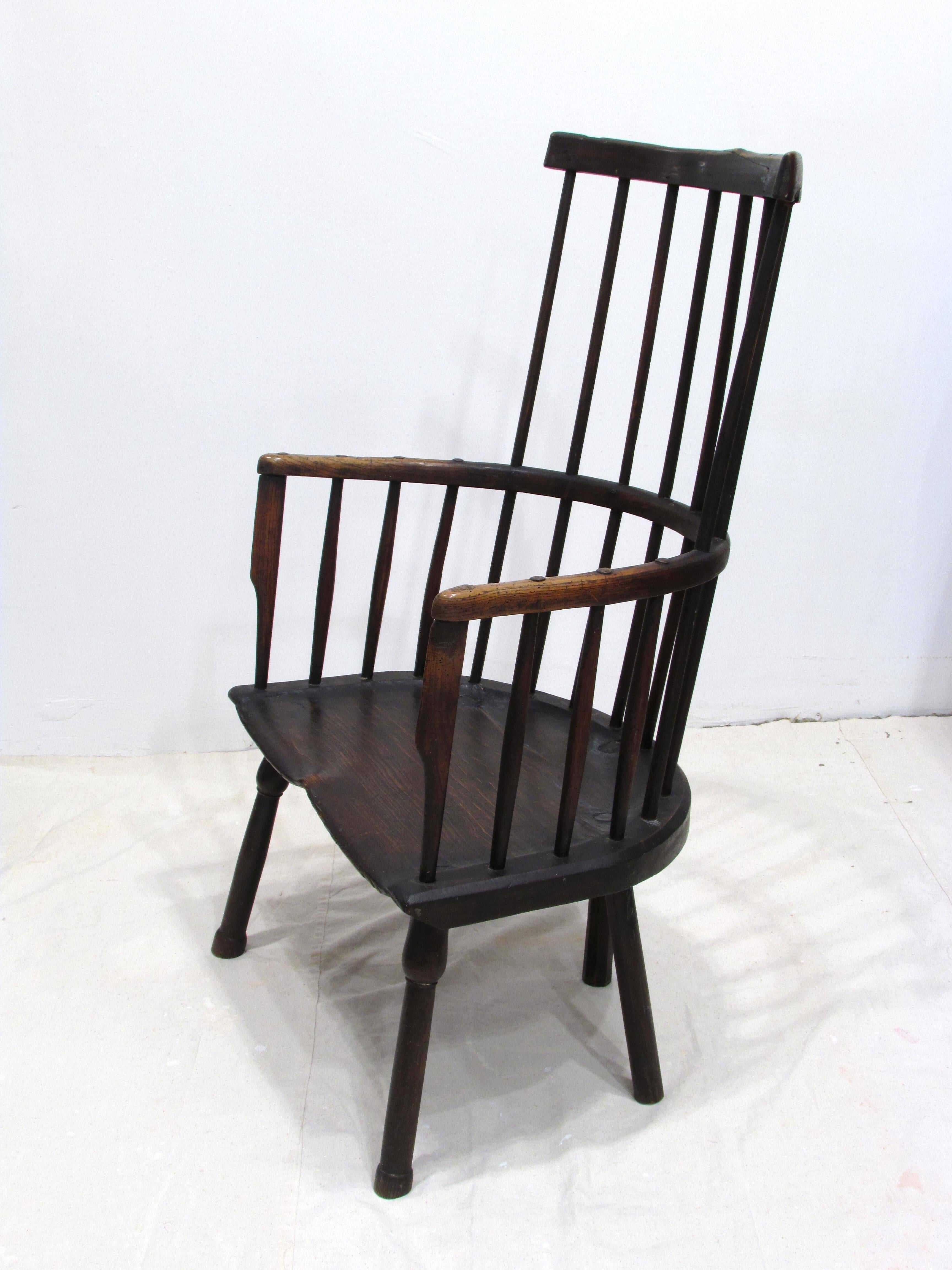 Beautiful worn and patinaed wooden comb back Windsor style armchair with five legs