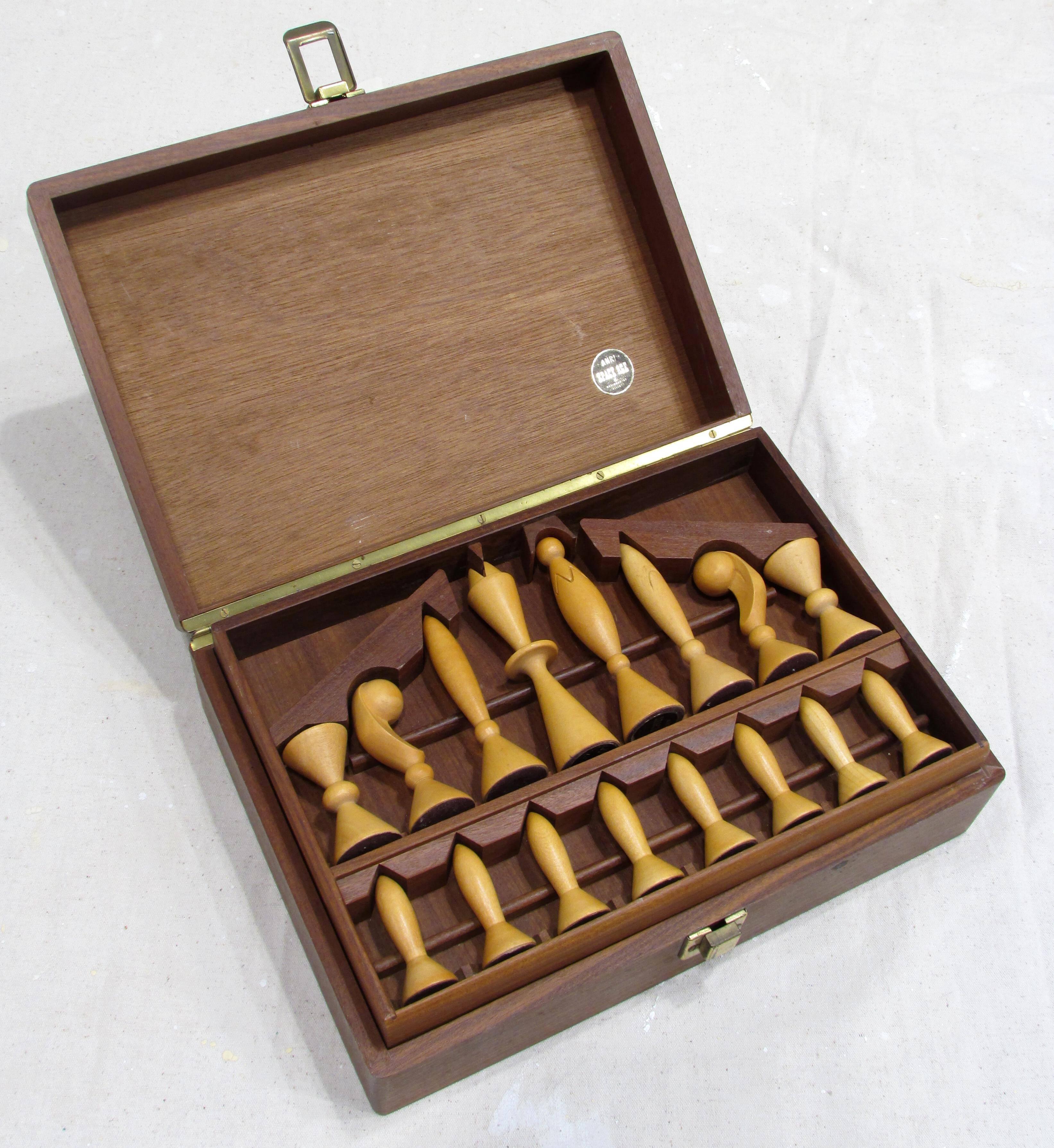 Beautiful carved "Space Age" chess set pieces designed by Arthur Elliott for ANRI contained in a hinged box with removable compartmentalized tray to contain the lighter wood pieces and in the bottom are the darker wood pieces marked with