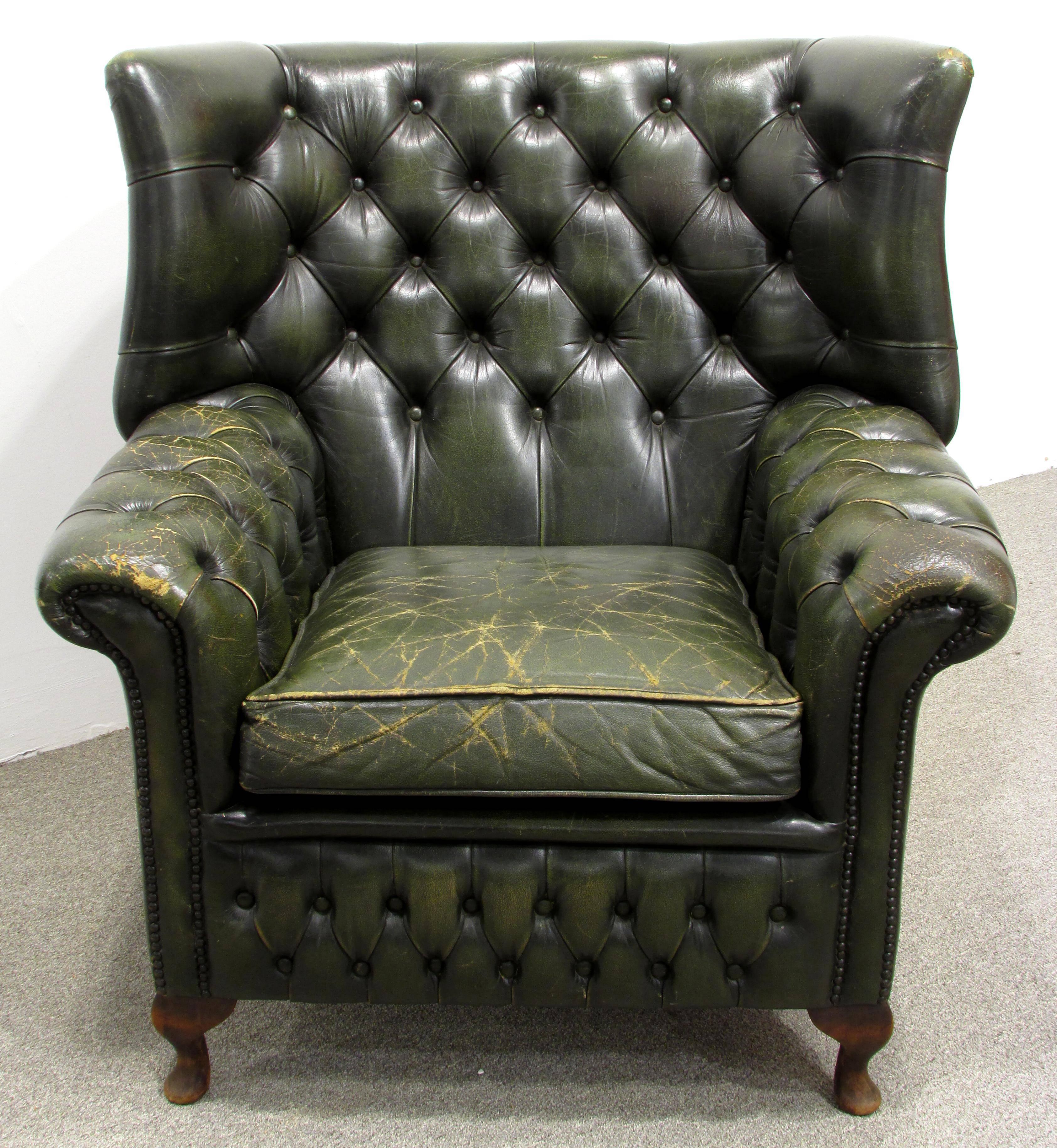 Beautiful worn and weathered green leather tufted wingback chair with nailhead decoration.