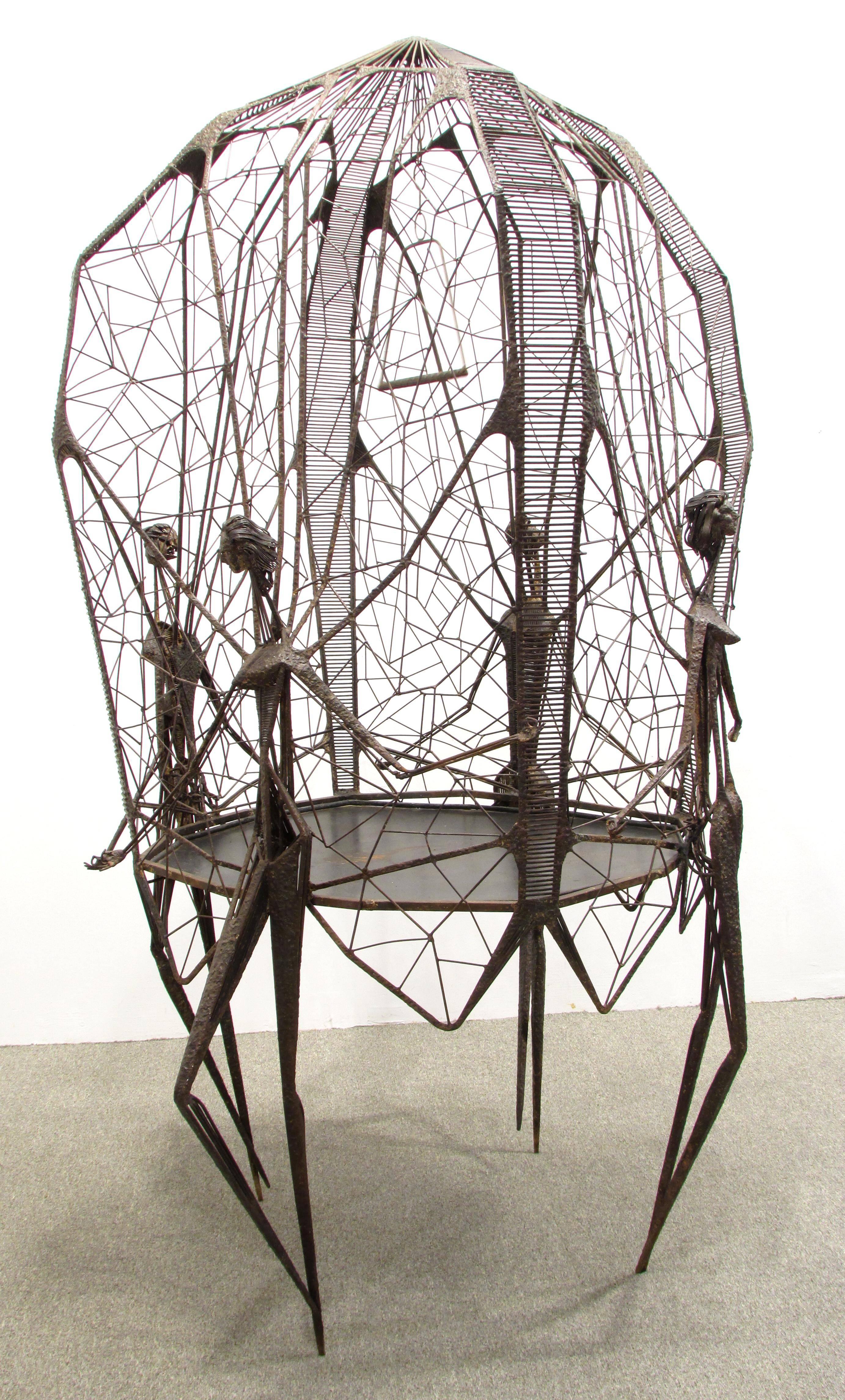 Large artist made modernist style birdcage made of welded metal resembles spider web the cage supported by four cubist style women.