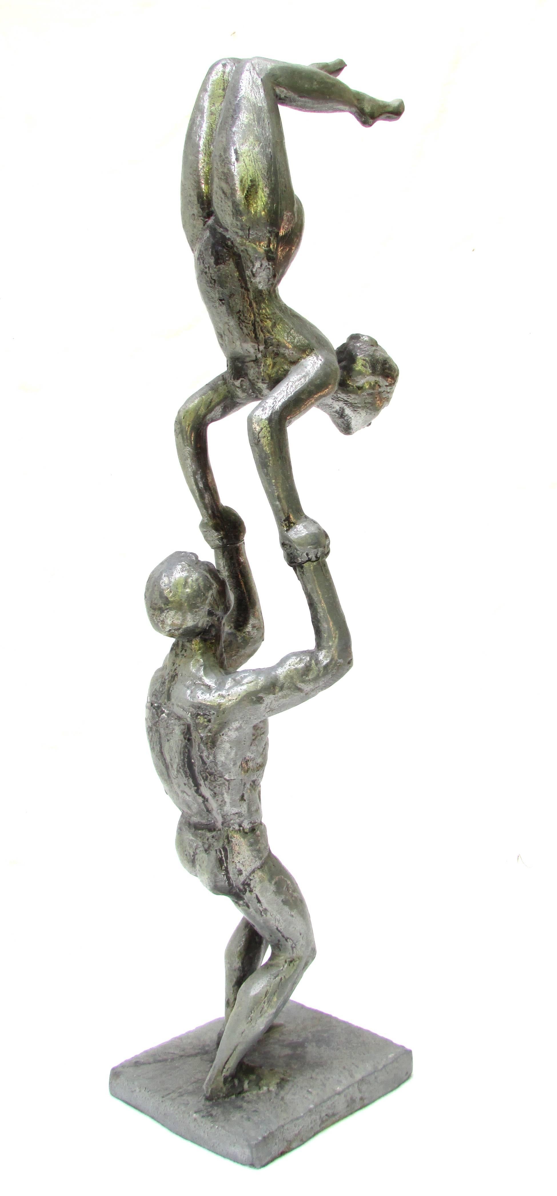 Cast aluminium sculpture of two acrobats performing a balancing act.