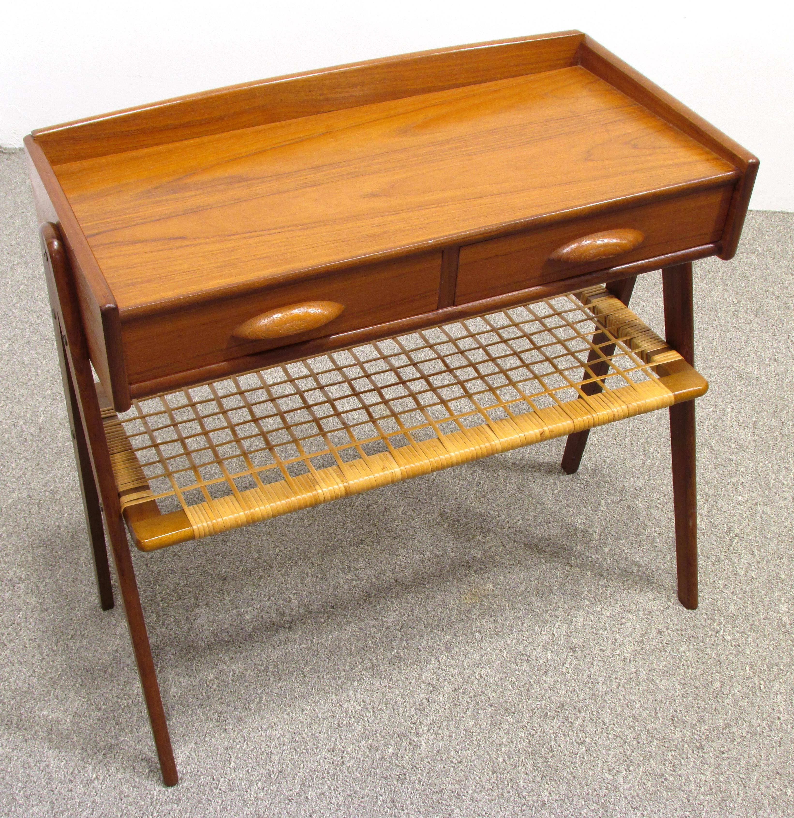 Small scissor leg teak hall table with two drawers and wicker wrapped shelf.