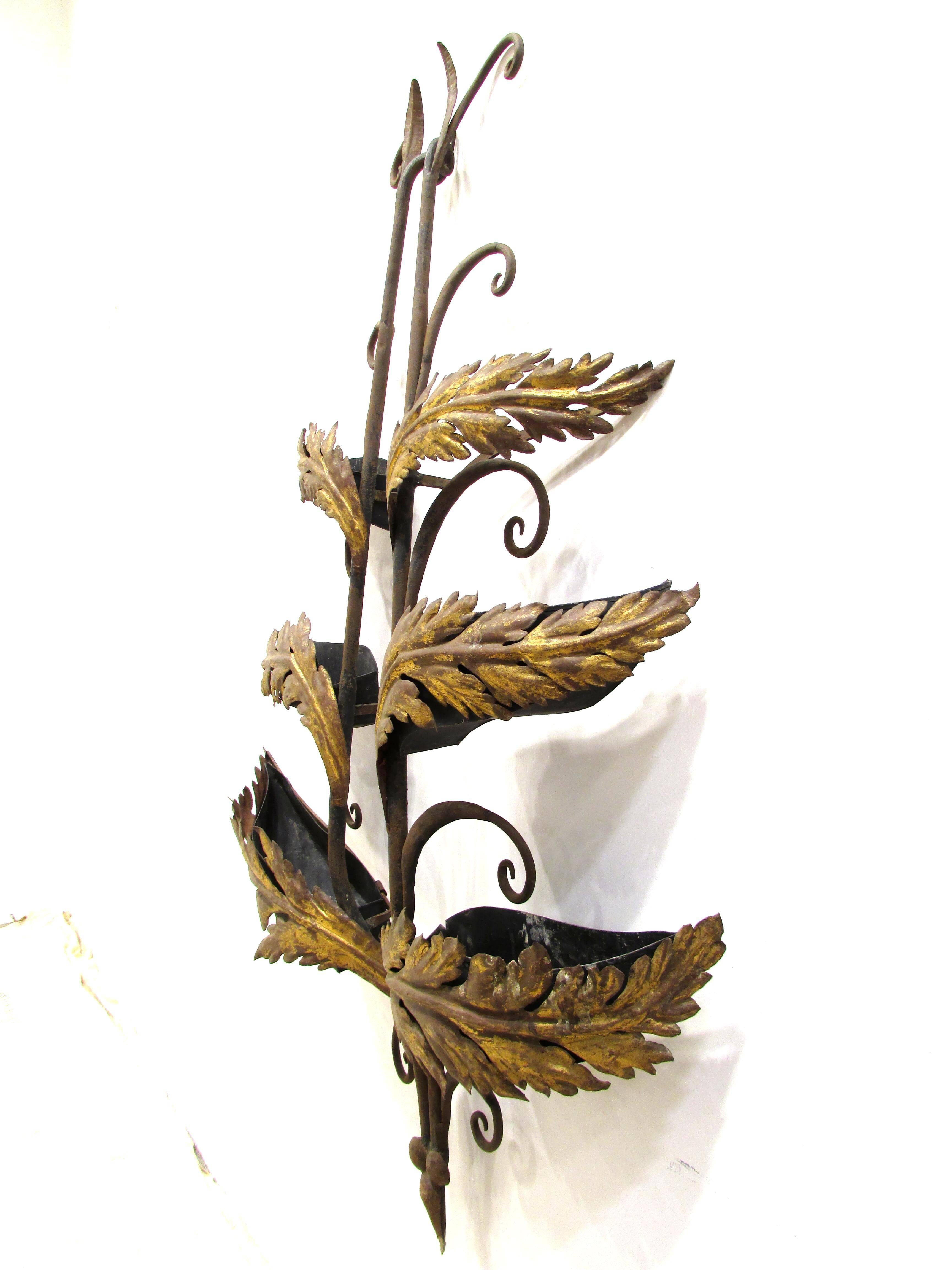 Handmade hand-wrought iron garden wall hanging sculpture with gilt leaves has inset metal containers being the gilt leaves which once held live plants or moss.