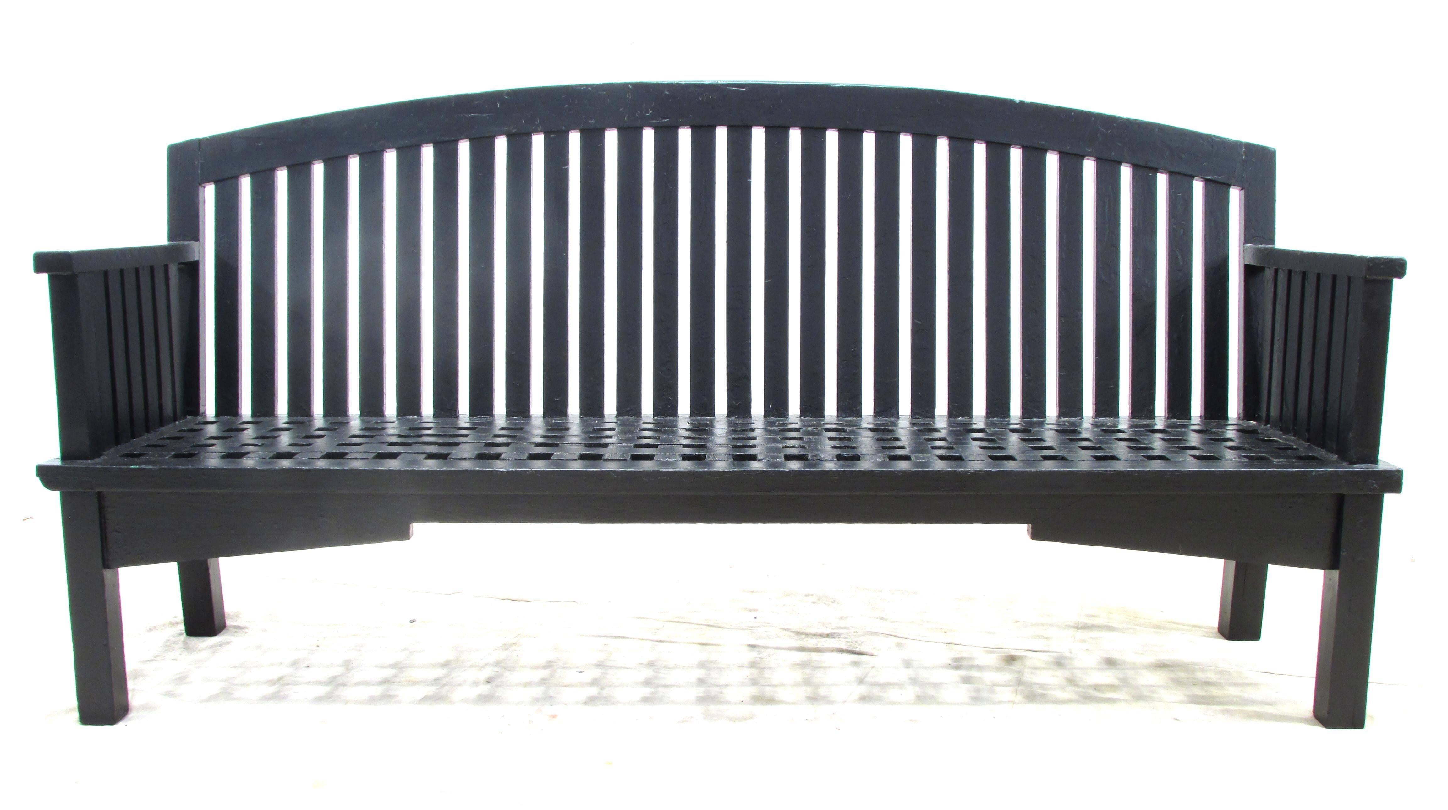 Black painted long wooden garden bench with intricate designed seat and back from Philadelphia late 19th century to early 20th century.