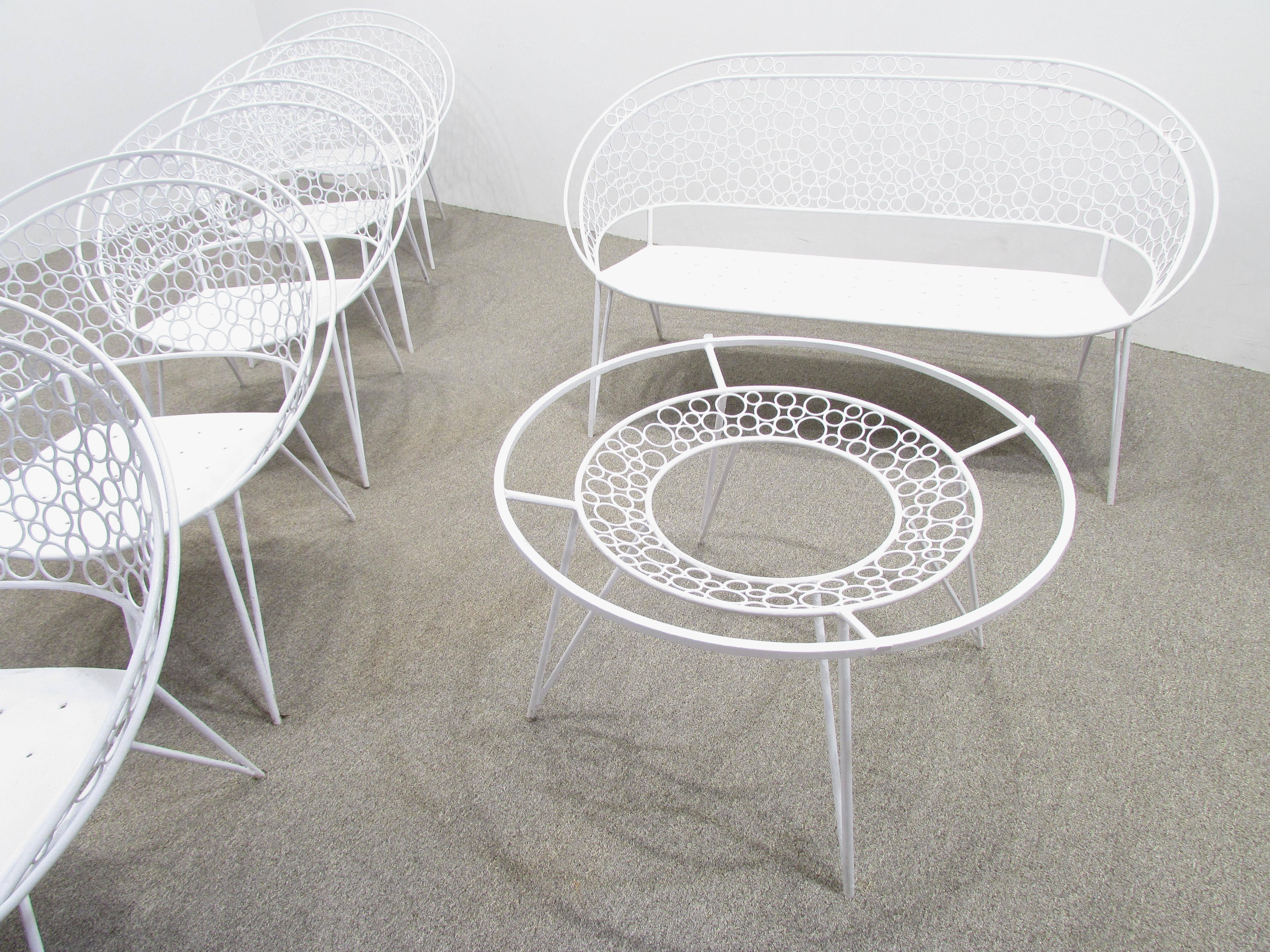 White painted garden set consisting of six hoop design chairs a settee and a cocktail table each filled with circles amazing handwork on this set.