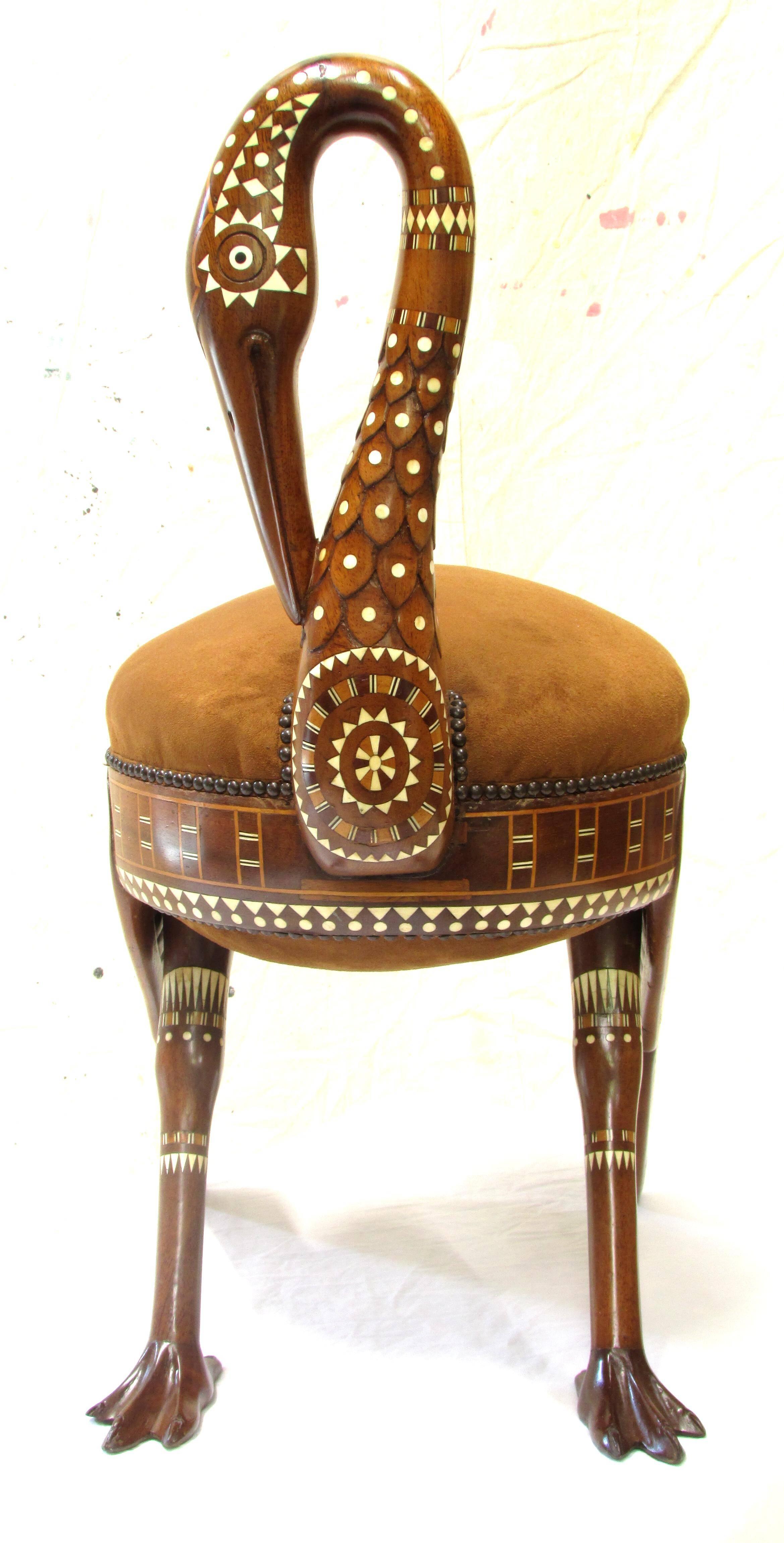 An Egyptian revival inlaid cedar wood stool in the form of a sacred Ibis with padded oval seat on stylized wings and legs, made of cedar with inlaid bone, sandalwood and mahogany the stool was made at the height of the Egyptian mania following the