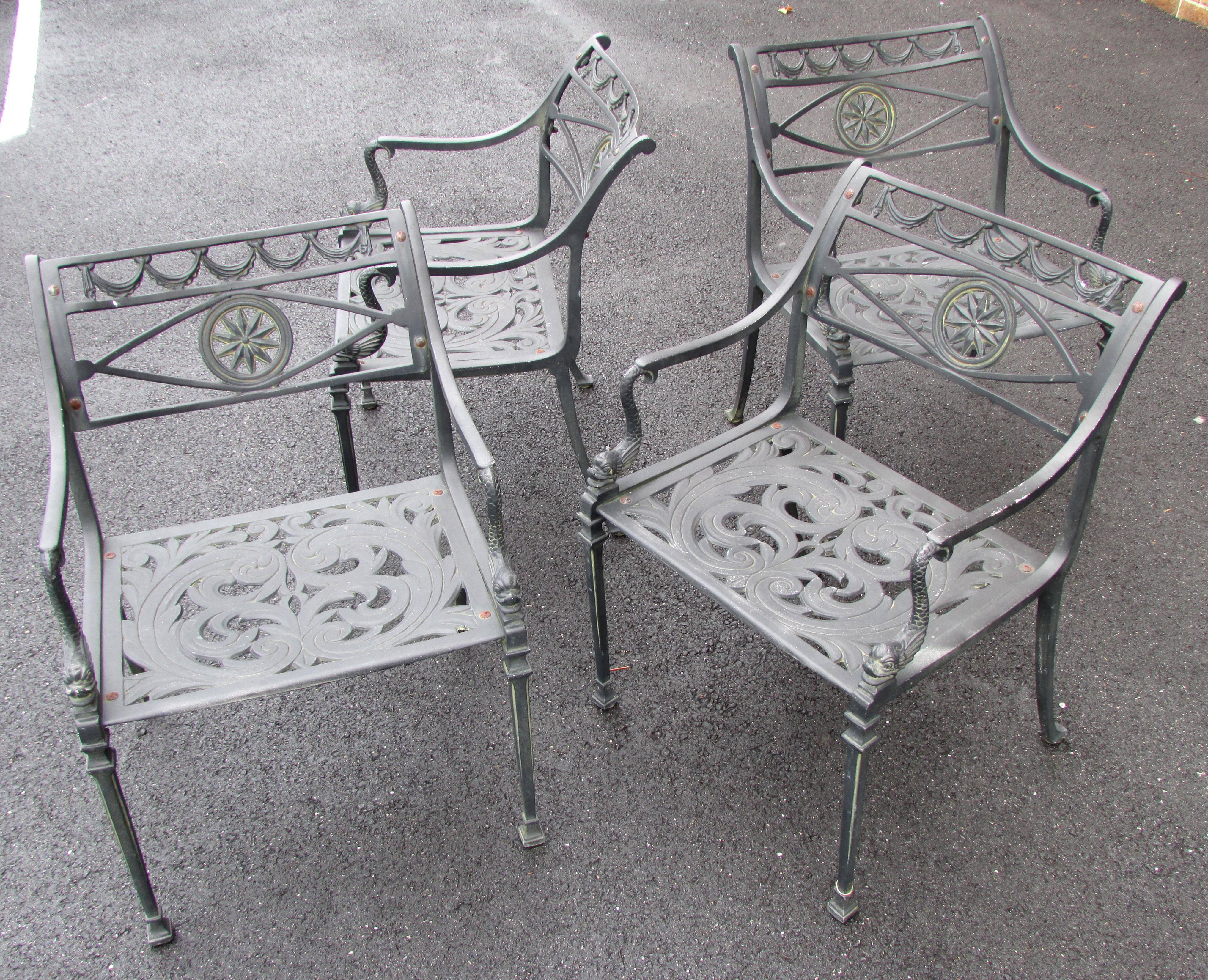 Set of four neoclassical cast metal garden chairs with dolphin arms and sun motif back