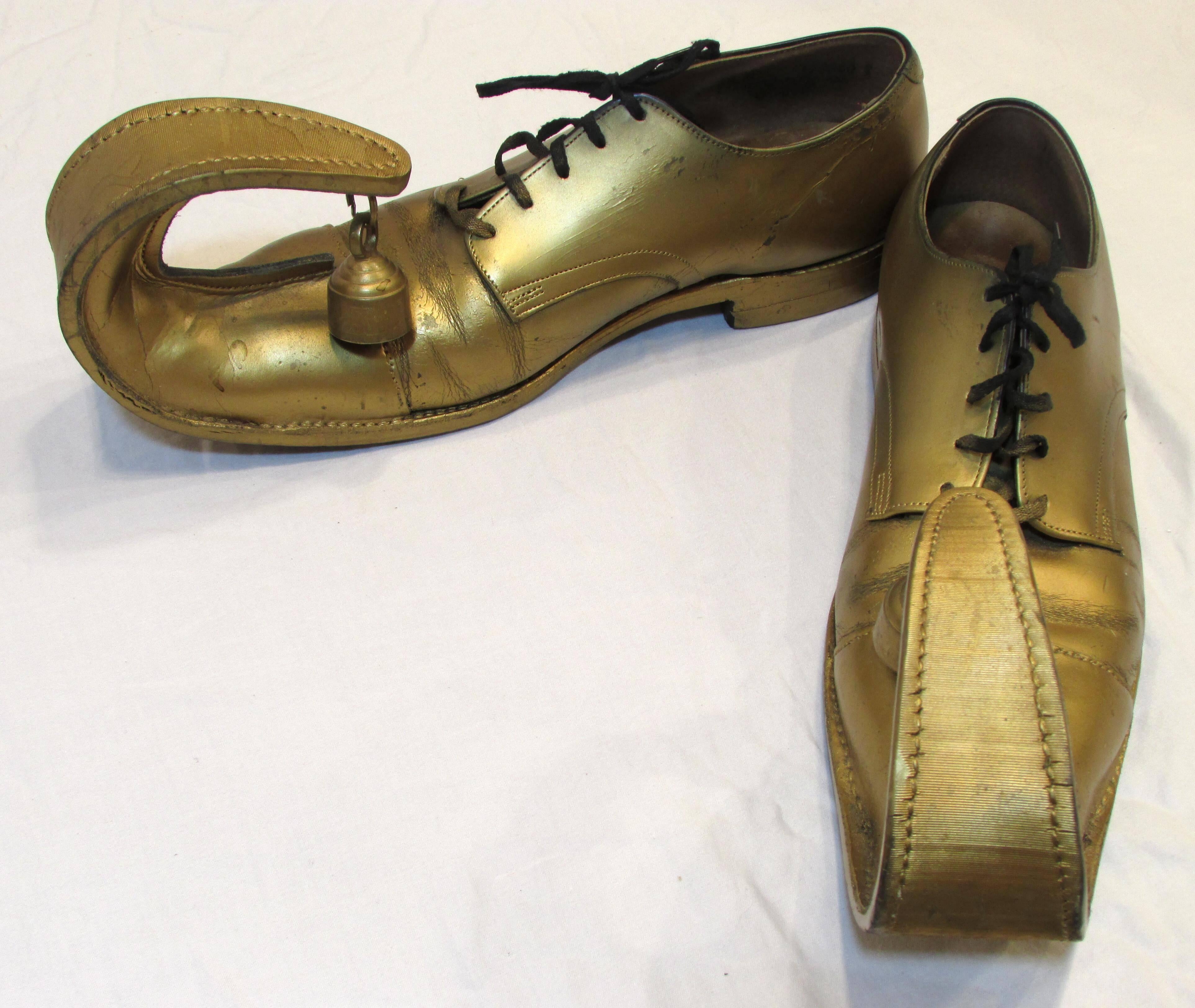Gold painted clown shoes with large curled up toes with brass bells attached.  size 10
From my collection of vintage Clown Shoes.
