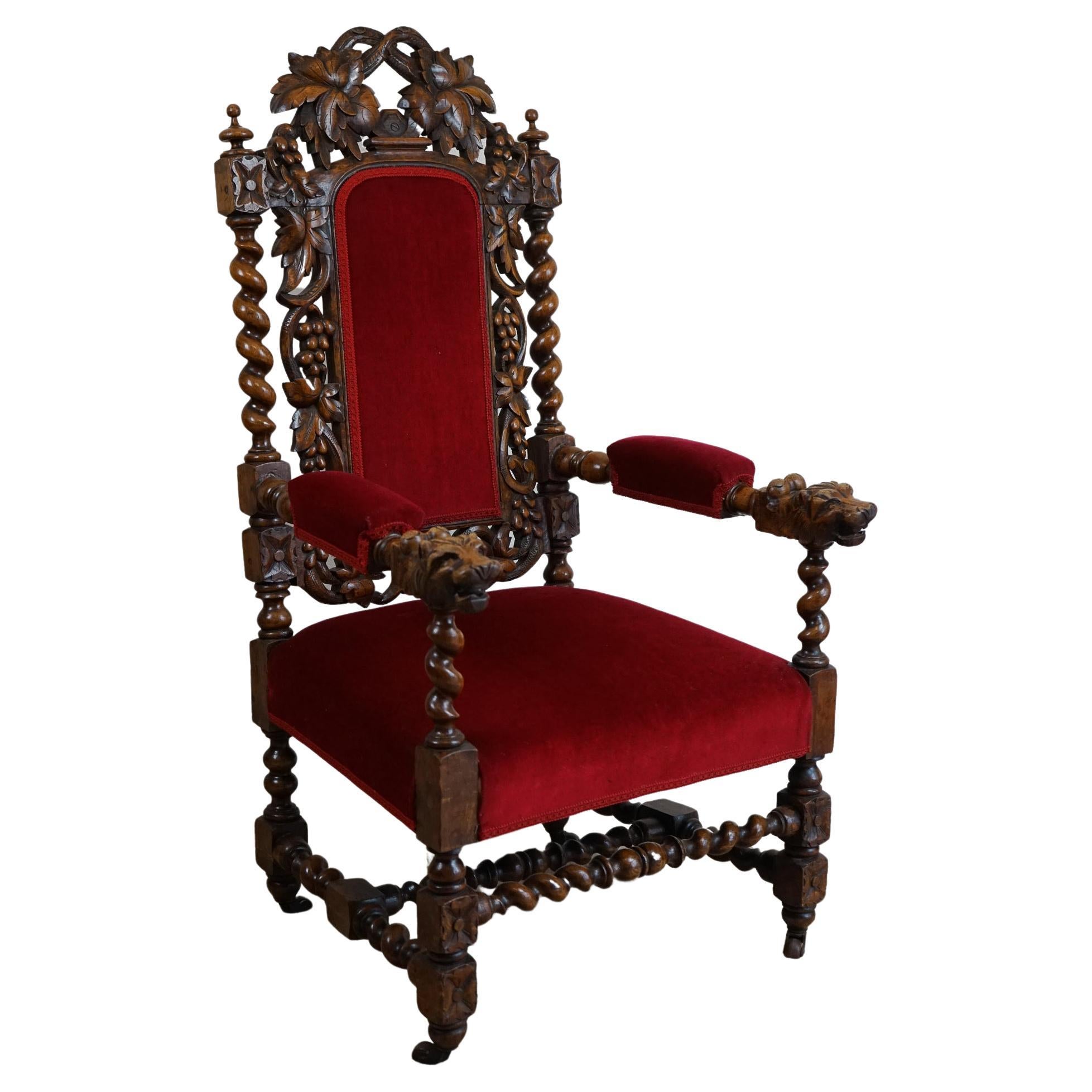 Carved oak throne high back chair with carved backrest. Each armrest has a carved lion head. The seat and back is upholstered in beautiful original red material and filled with horse hair , this particular throne chair is made in UK between