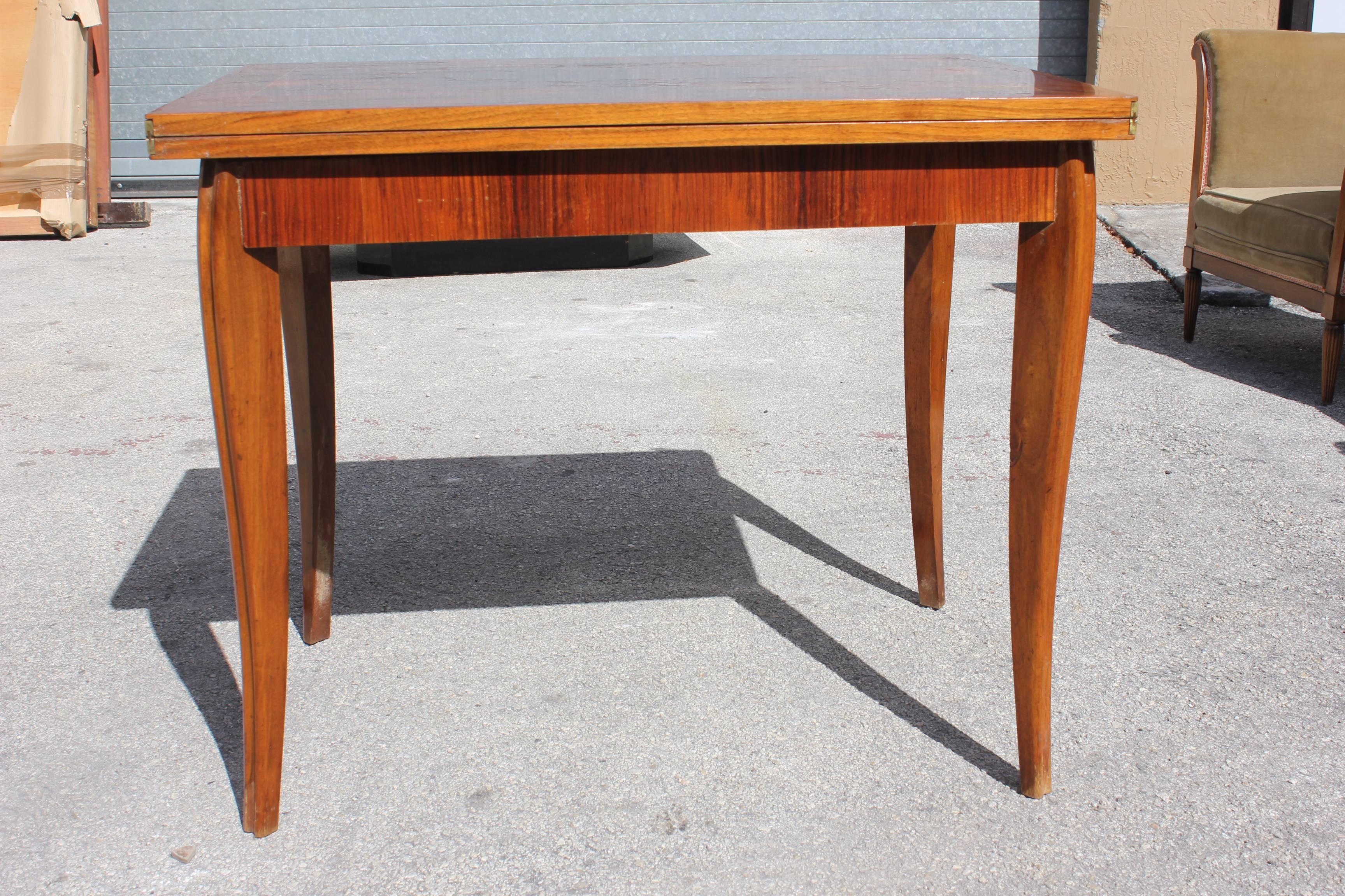 A French Art Deco exotic walnut gaming table, circa 1940s. Sabre leg, extending top. When open extends to 47-1/2