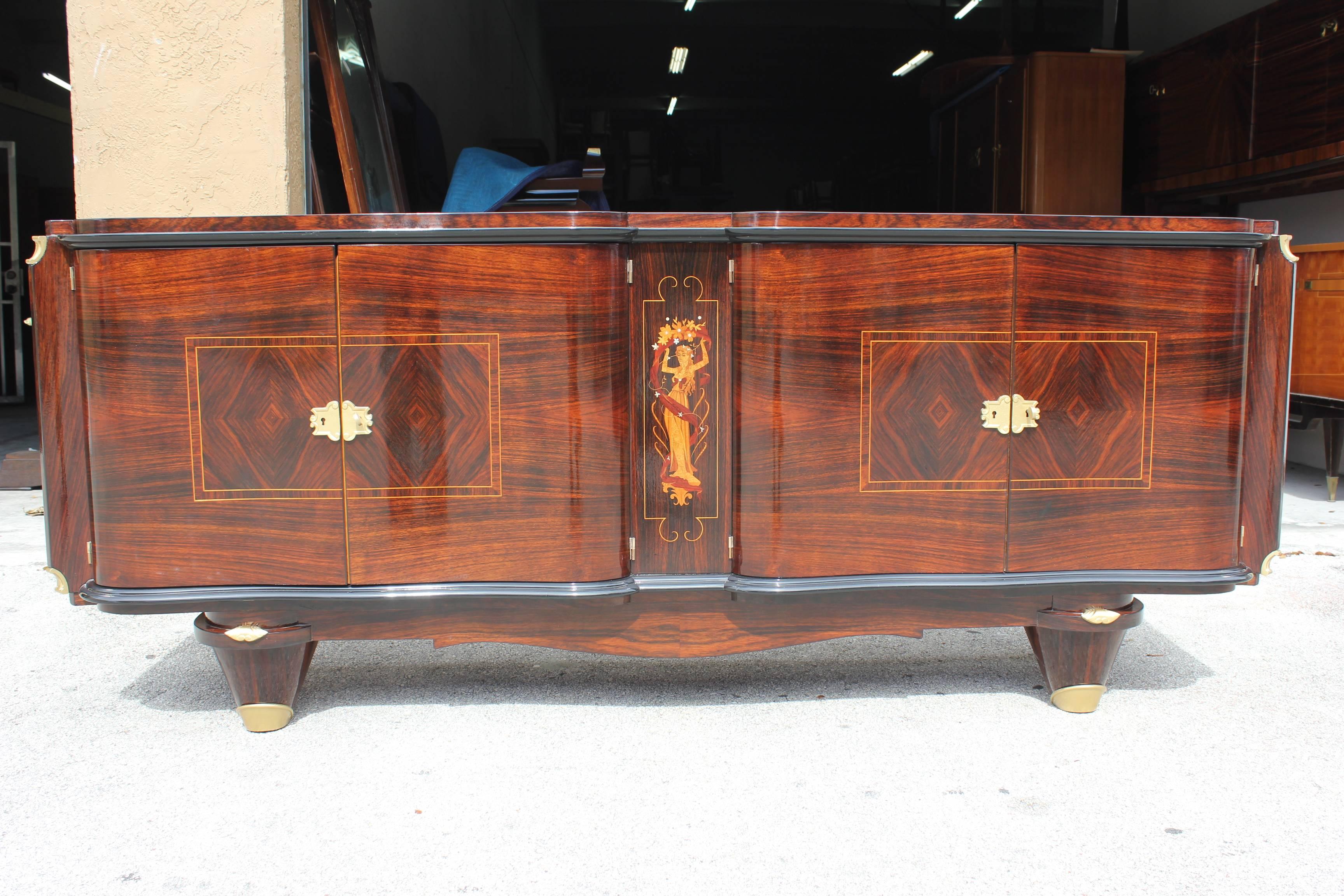 A stunning French Art Deco sideboard / buffet  Palisander Rio with Mother of Pearl Detail, circa 1940s. Style of the master, Jules Leleu. Center female figure with Mother of Pearl accents. Elaborate hardware.(beautiful restoration and refinished