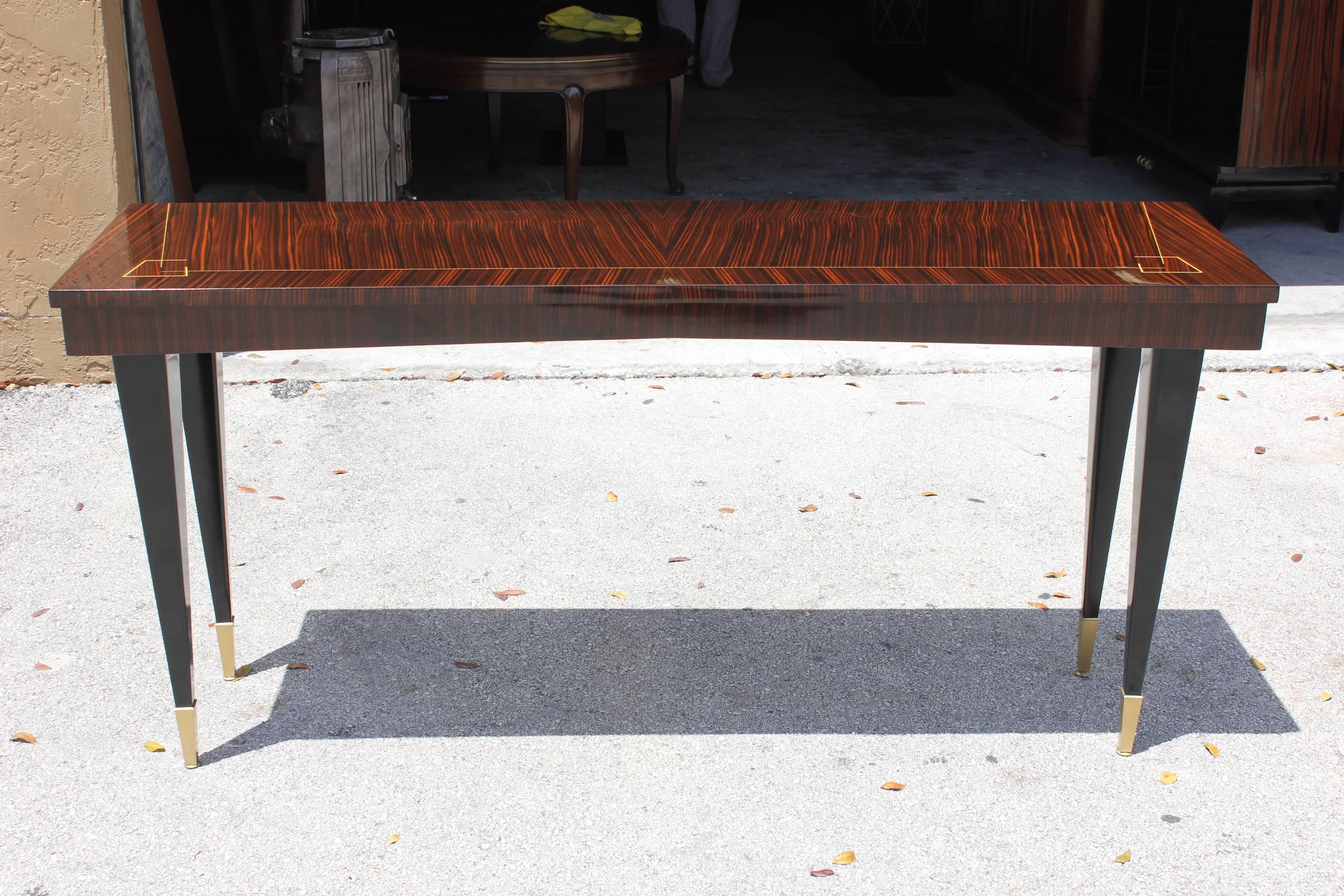 A long French Art Deco Exotic Macassar Ebony Console Table, circa 1940s. Beautiful inlay, black lacquer legs. Capped toes. french estate item. Pair available.