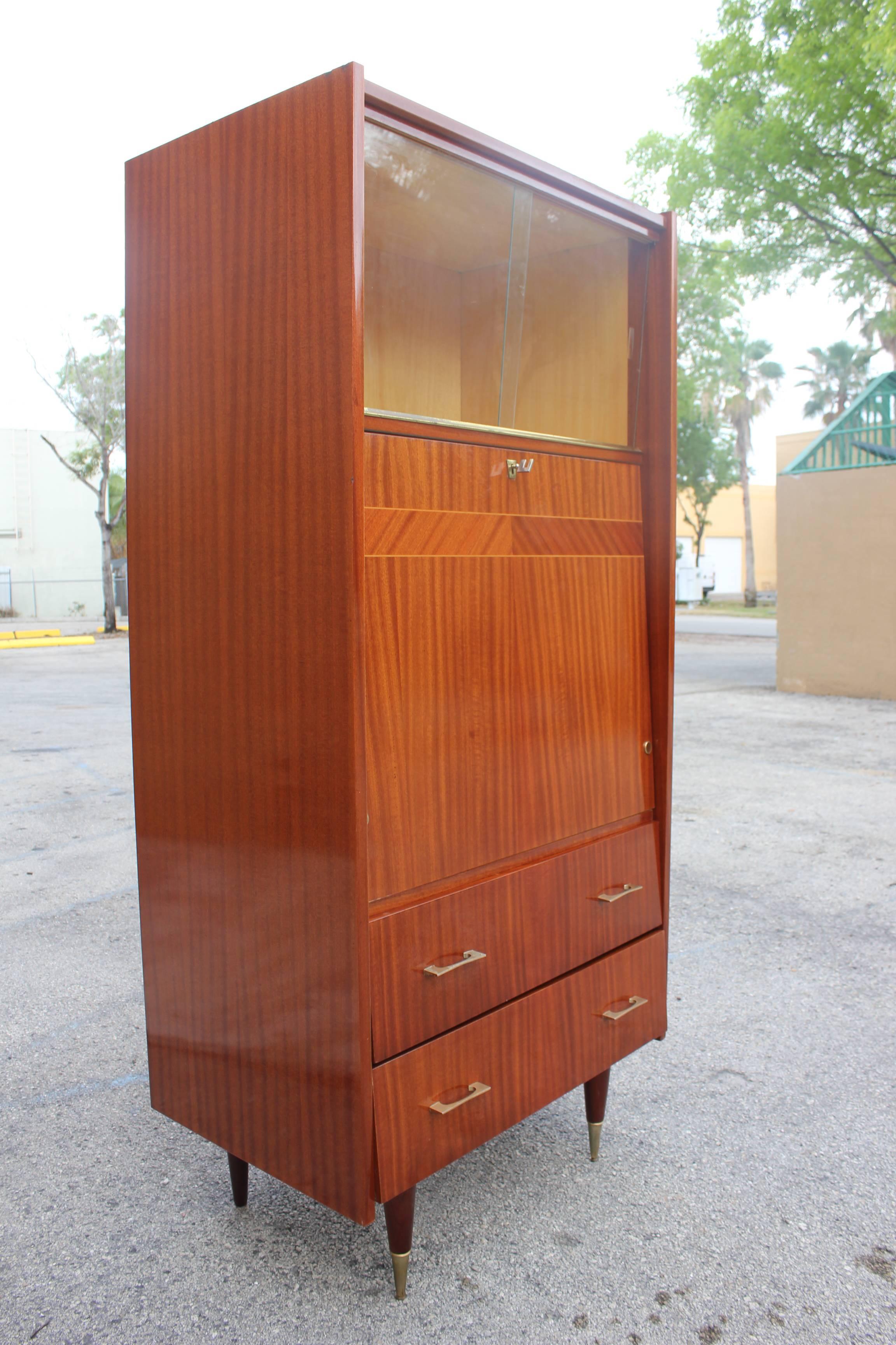 A French Art Deco palisander Rio secretary, circa 1940s. Finished interior. Upper glass sliding doors. Drop down front, lower drawers.
