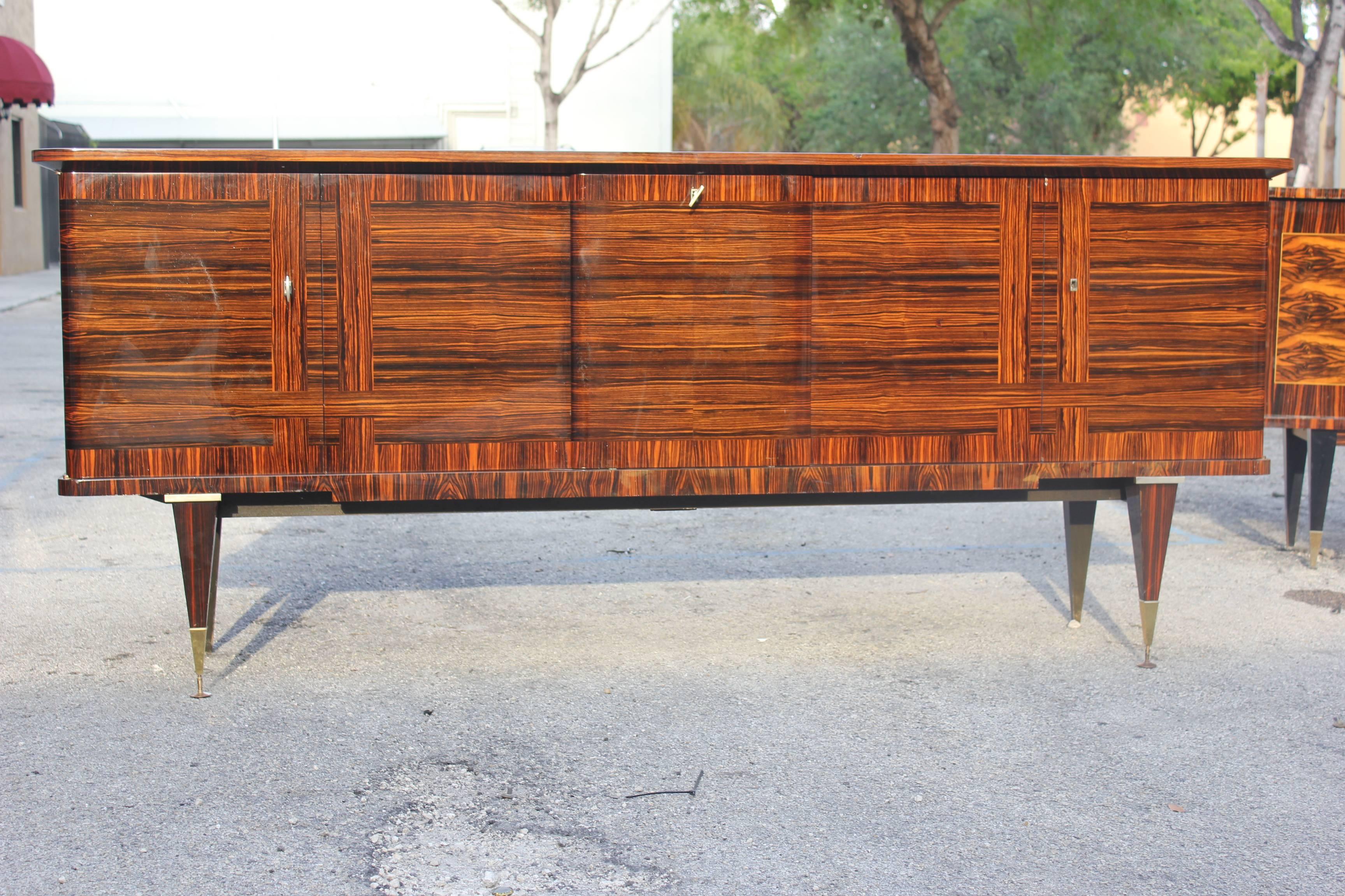 A large French Art Deco exotic Macassar ebony grand buffet, circa 1940s. Beautiful detail, finished interior. Center drop down bar area. Excellent condition.