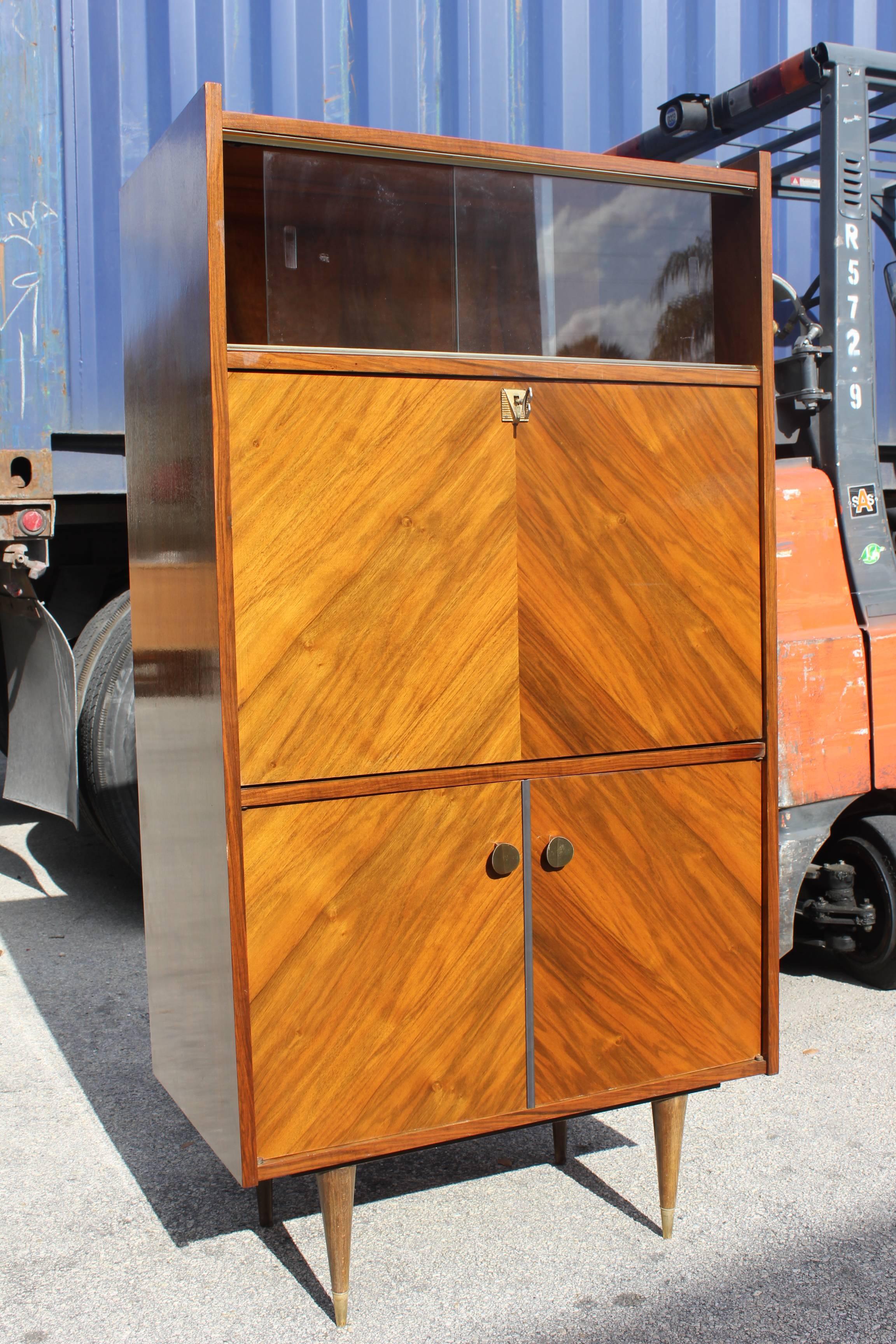 A French Art Deco exotic walnut secretary, circa 1940s. Upper sliding glass doors, drop down front, lower storage.