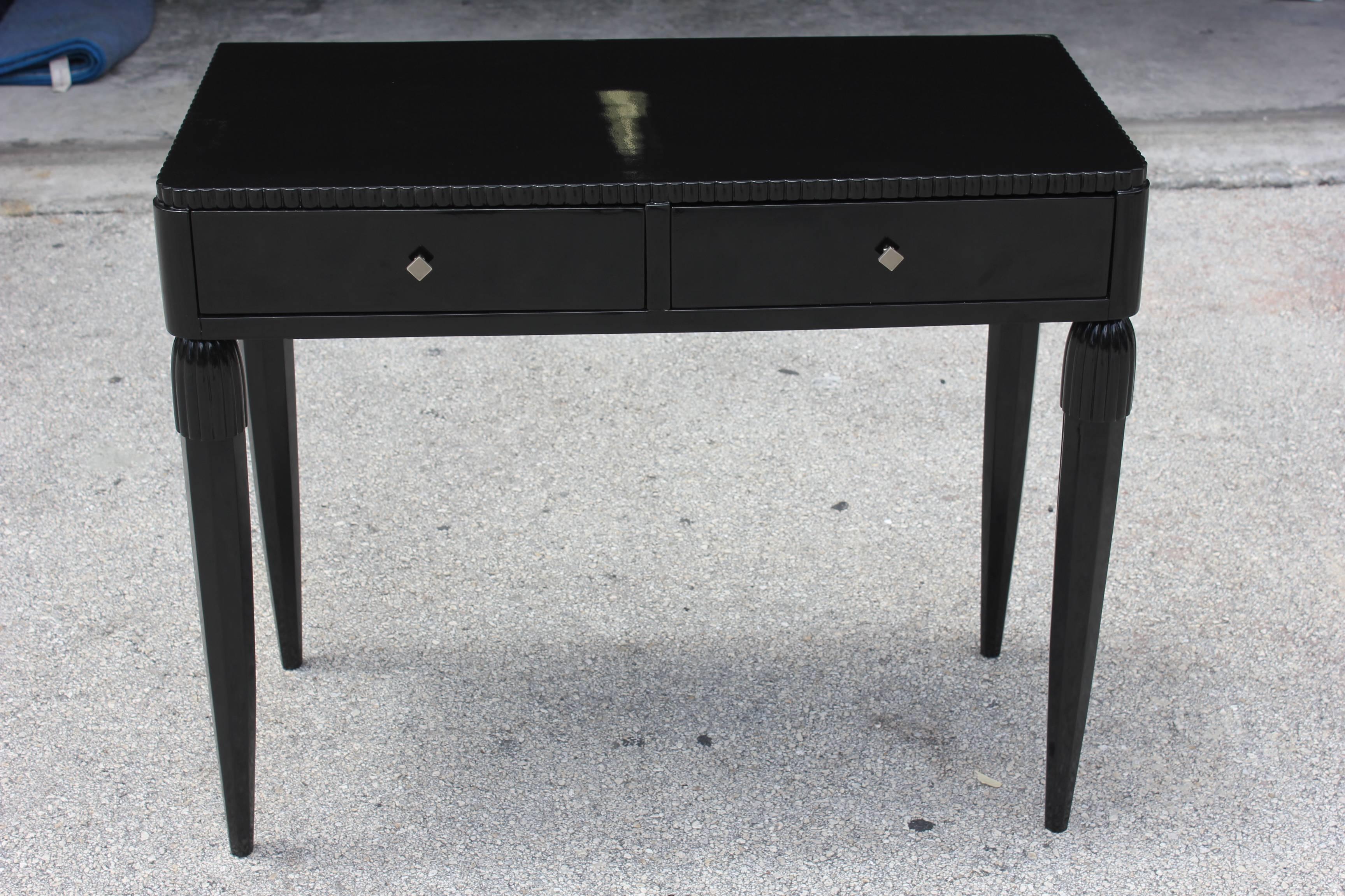 A French Art Deco detailed black lacquered console table, circa 1940s. Beautiful carved detail. Two drawers.