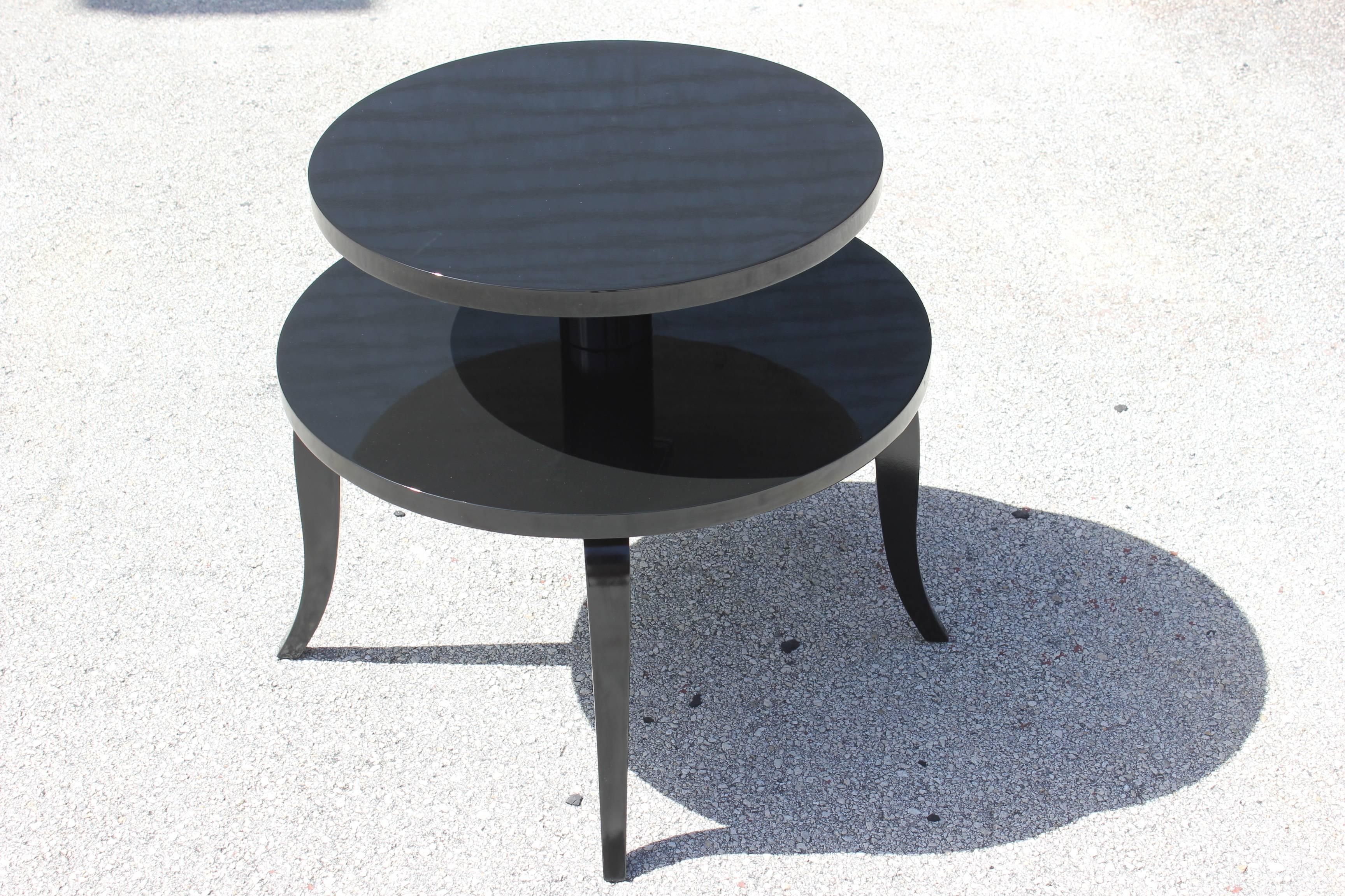 A French Art Deco black lacquered two-tier accent table, circa 1940s. Newly refinished and lacquered. Beautiful sabre legs.