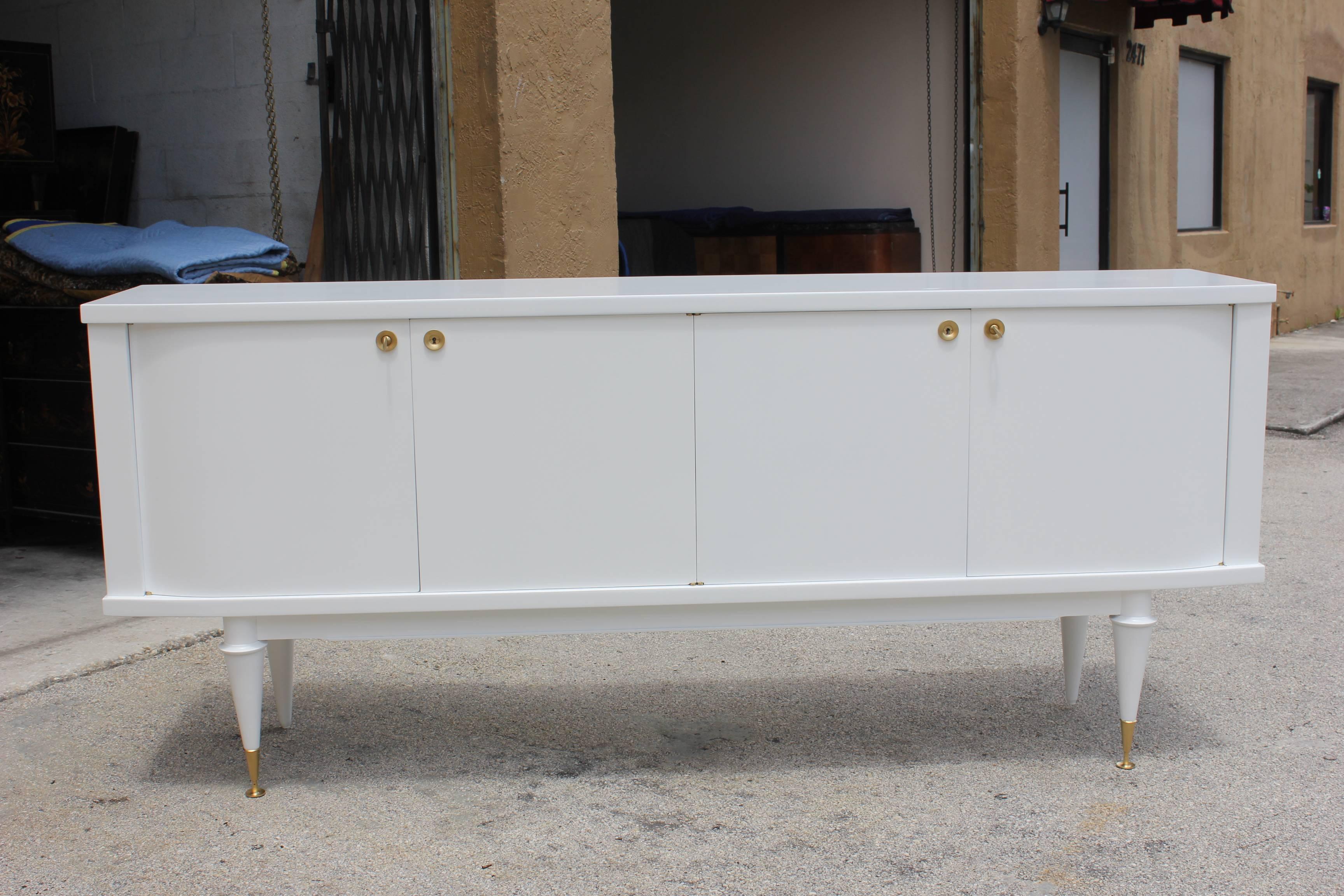 A French Art deco / art  Modern snow white lacquered sideboard, circa 1940s. Freshly lacquered in stunning white inside and out. Curved door detail on the left and right doors.