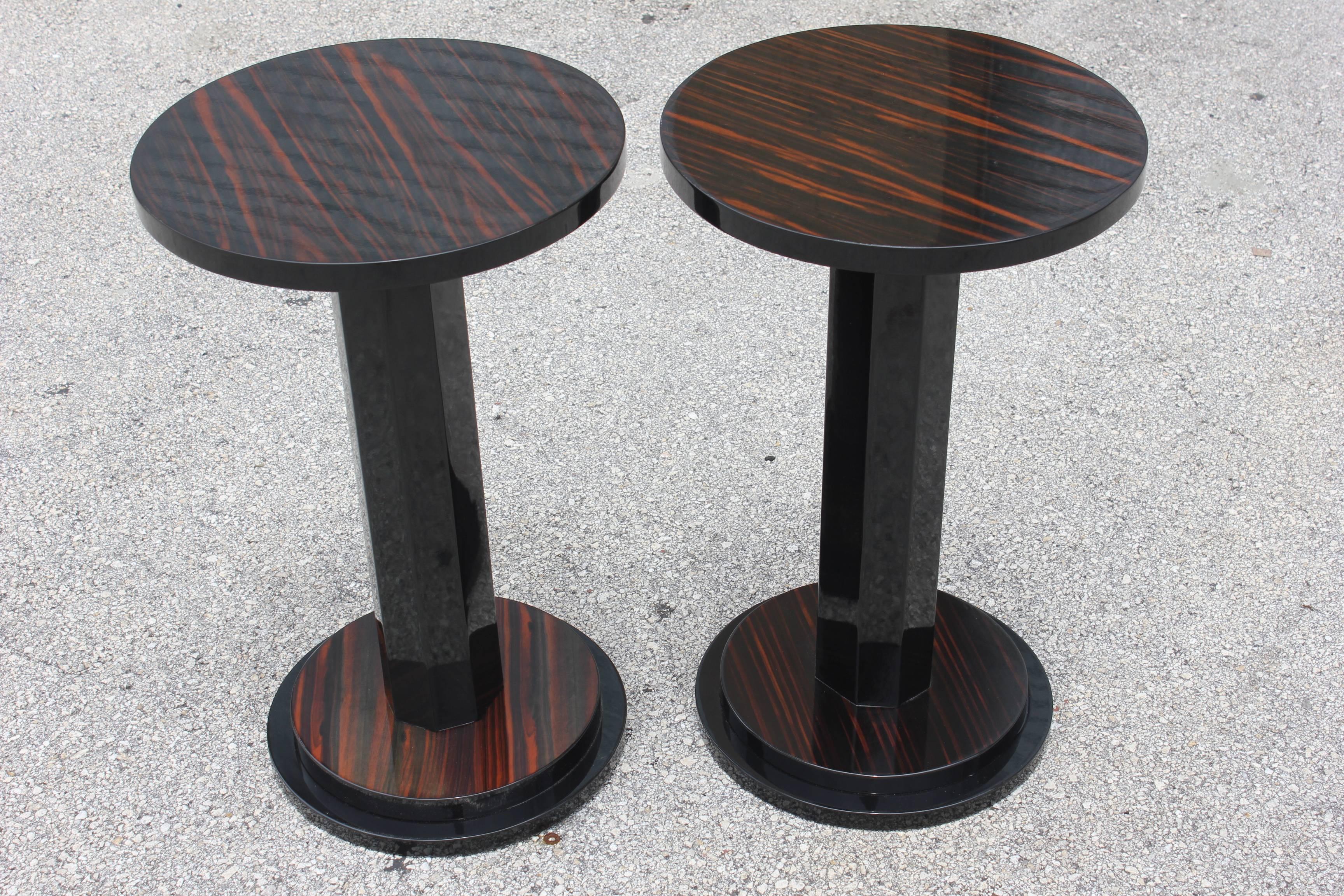 A pair of French Art Deco exotic Macassar ebony end tables, circa 1940s. Black lacquer center column and black lacquer two-tiered base. We acquired five pairs of these tables from the lounge of a French Hotel. There are slight variations to the