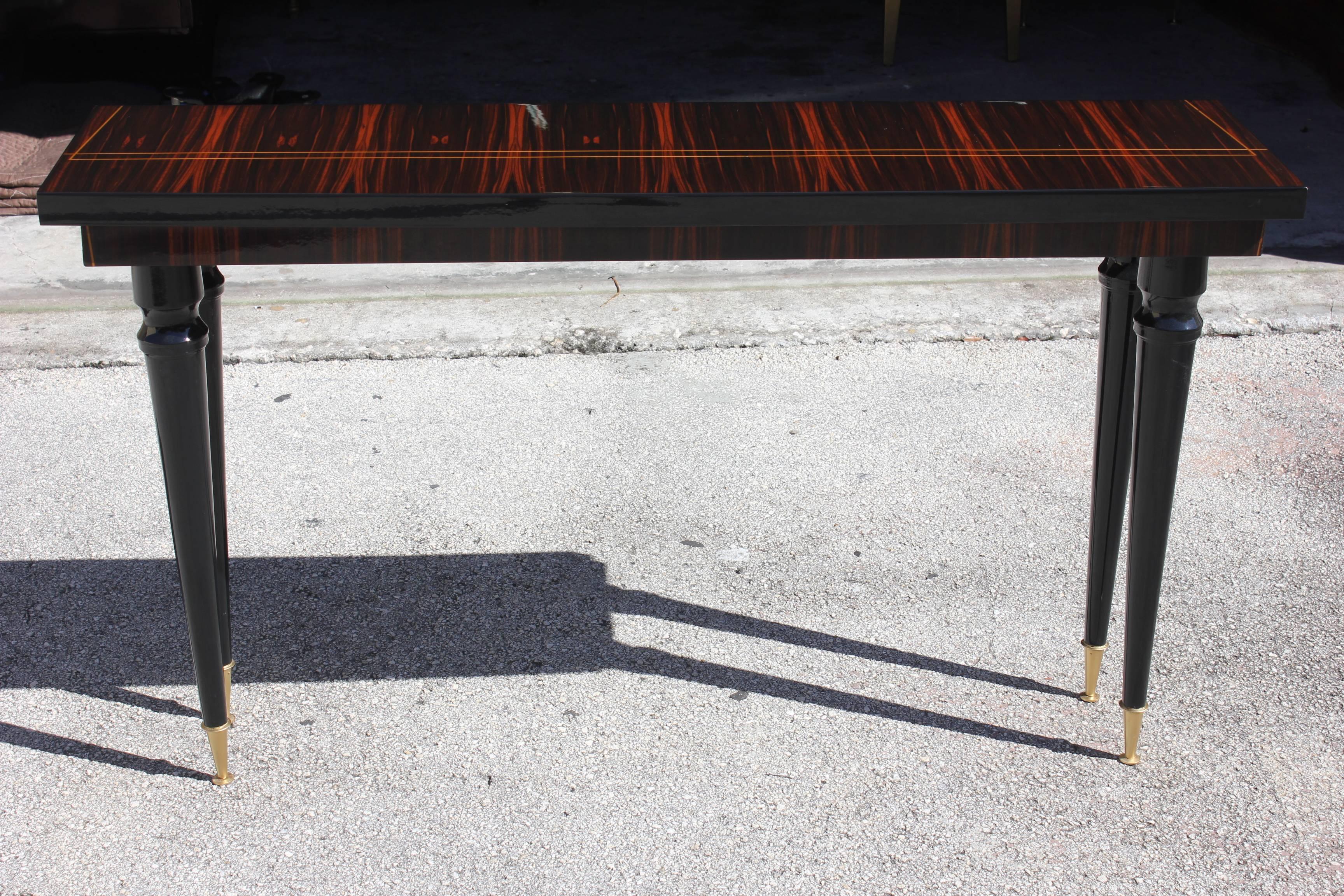 A beautiful French Art Deco exotic Macassar ebony steeped console table, circa 194s. Black lacquer legs, metal toe caps. Inlaid top, newly refinished and lacquered.
