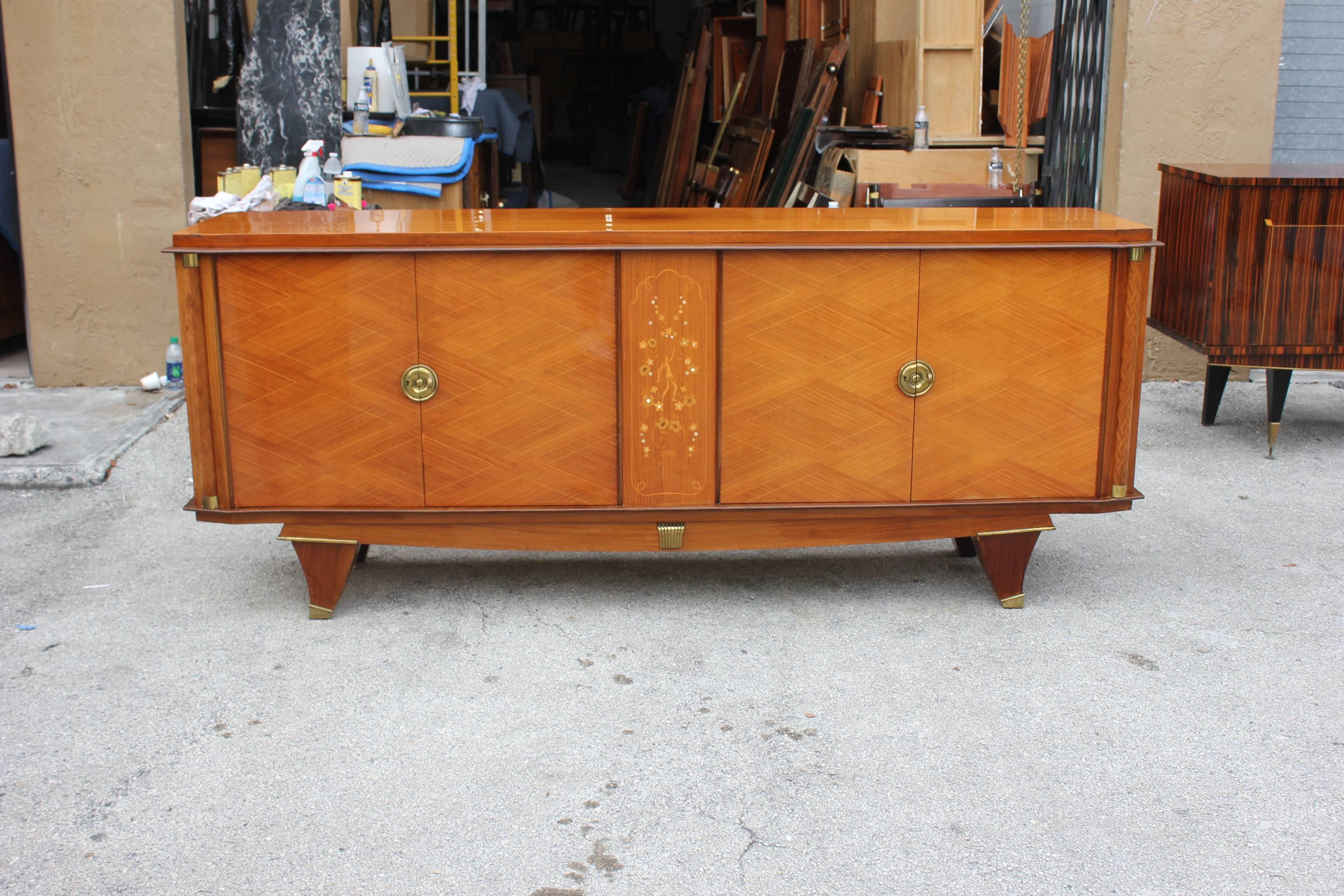 Stunning French Art Deco palisander (Brazilian rosewood) sideboard or buffet having beautiful mother-of-pearl inlay with gorgeous marquetry. Bronze detail, elaborate center panel, adorned with bronze hardware. In the style of Jules Leleu, circa