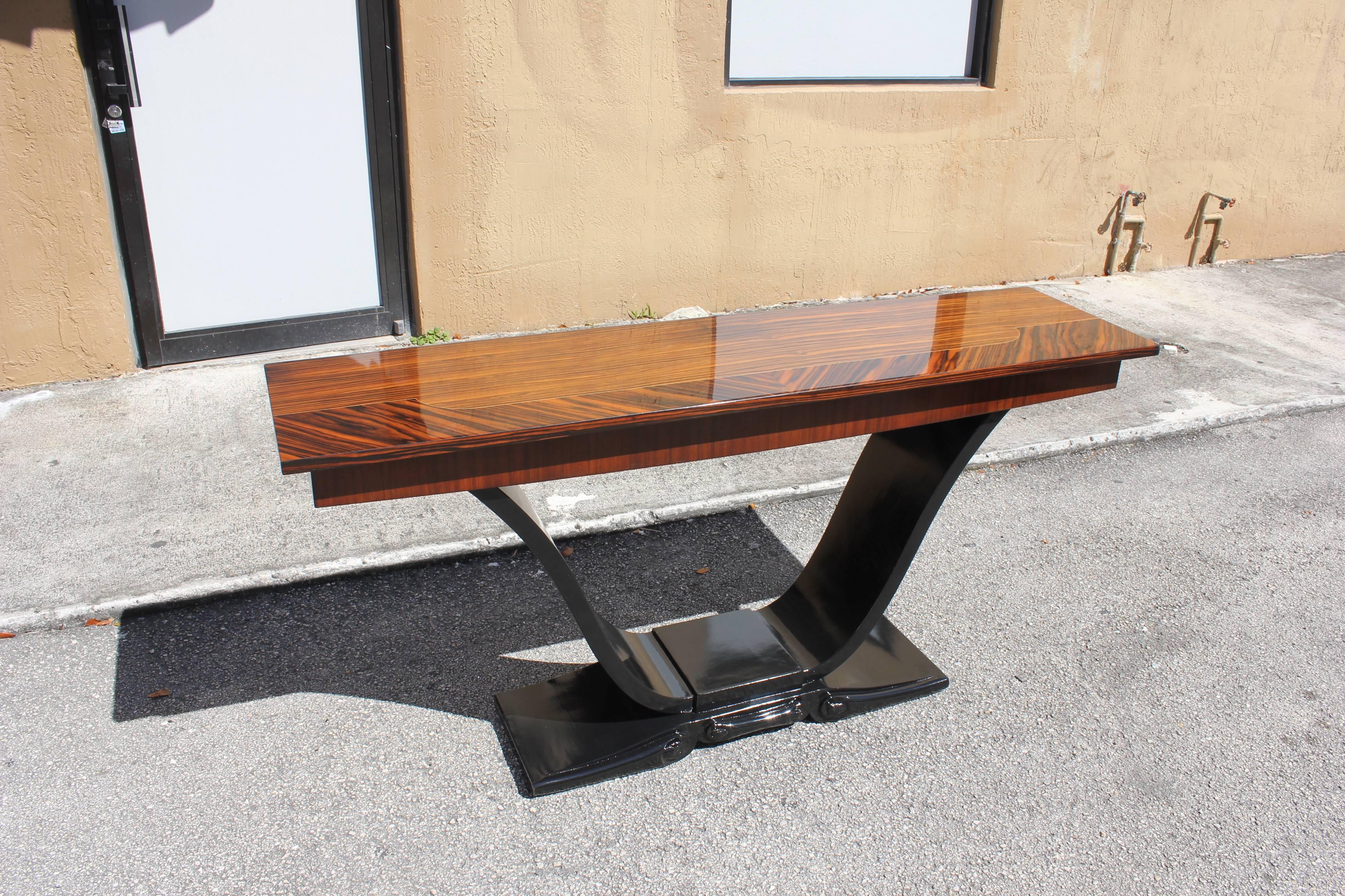 Spectacular pair of French Art Deco exotic Macassar ebony console tables, circa 1940s. Beautiful multi color Macassar ebony with black lacquer U-base, high gloss lacquer finish in both side, from France, Paris.