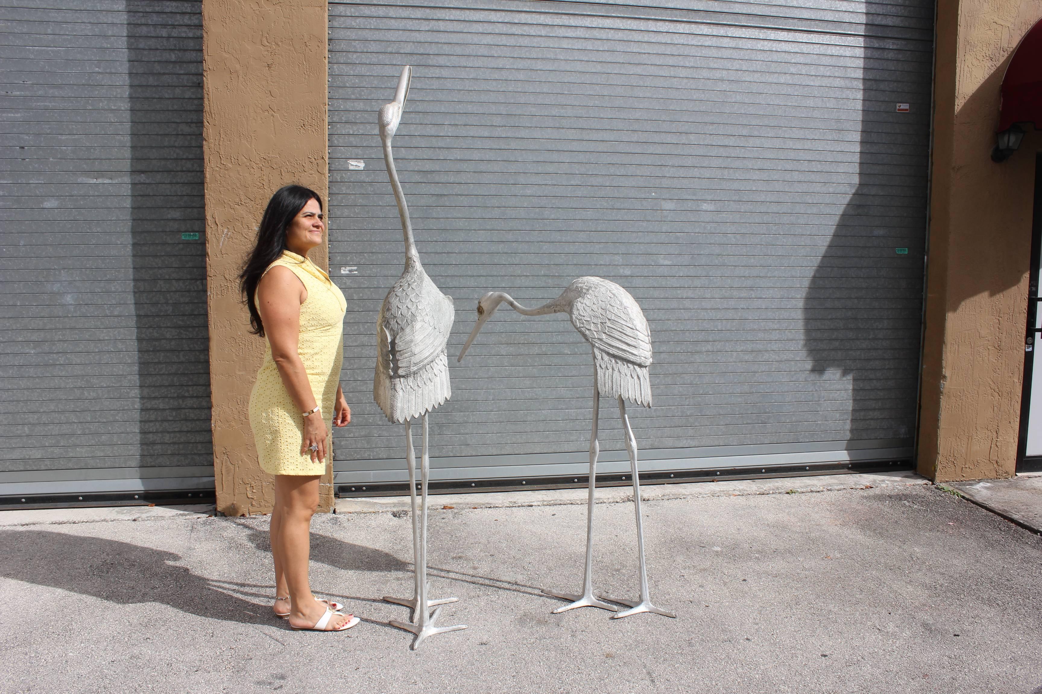 Beautiful pair of white matal Art Deco sculptures flamingos, circa 1950. The sculptures are finished in original color. The piece has a fantastic presence and they display very well indoors or outdoors. The pieces are very large in size standing at