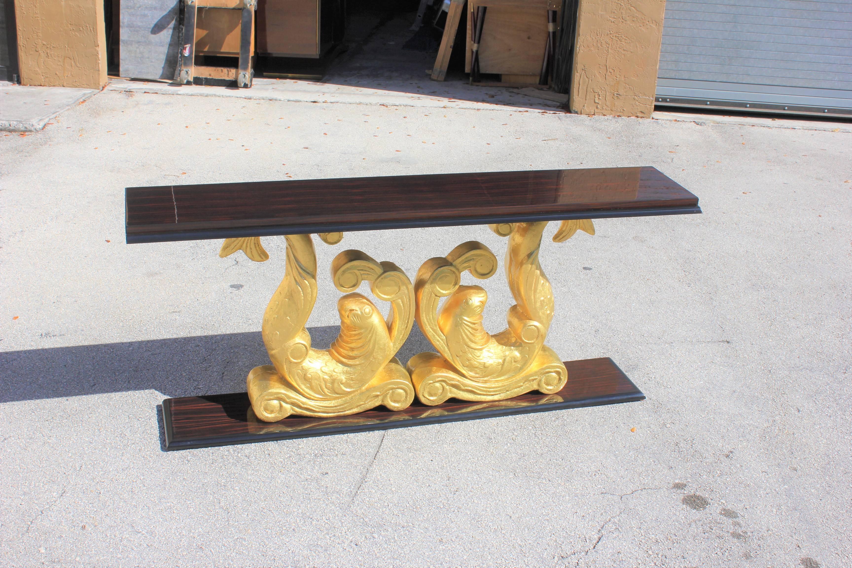 Unique long French Art Deco exotic Macassar ebony carved giltwood twin dolphin console table. Carved giltwood, original By Etienne Kohlmann. From France Monaco, circa 1930.