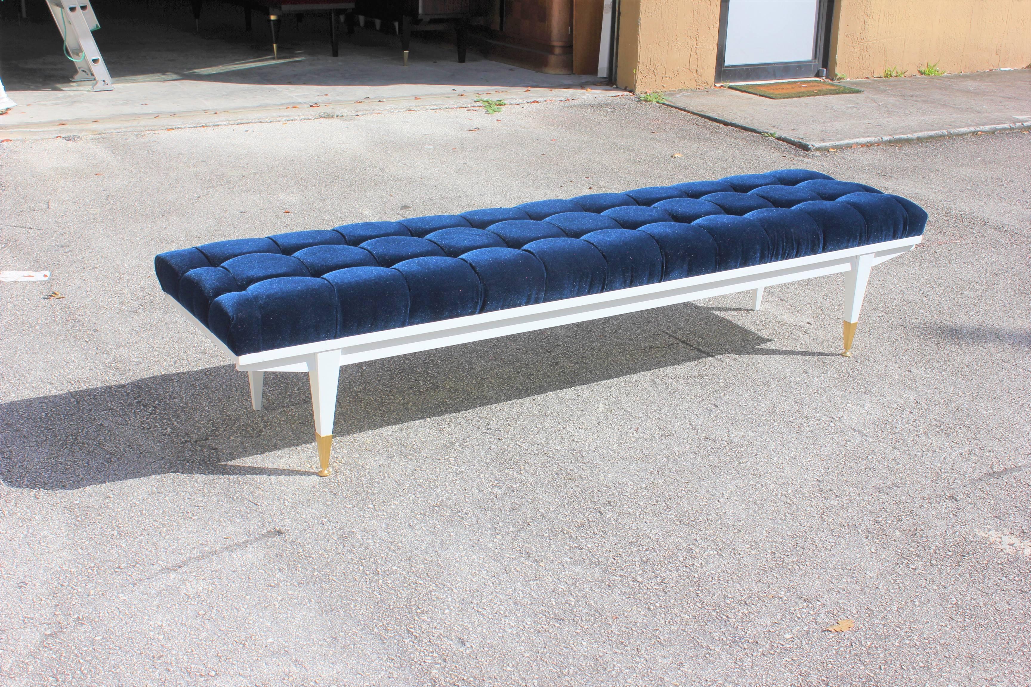 A long French Art Deco snow white lacquered Mahogany sitting bench, circa 1940s. Newly upholstered in a very high textile velvet royal blue. Newly refinished. White lacquer legs with brass caps. Size: 84 W, 20 D, 18 H we traveled to buy all our
