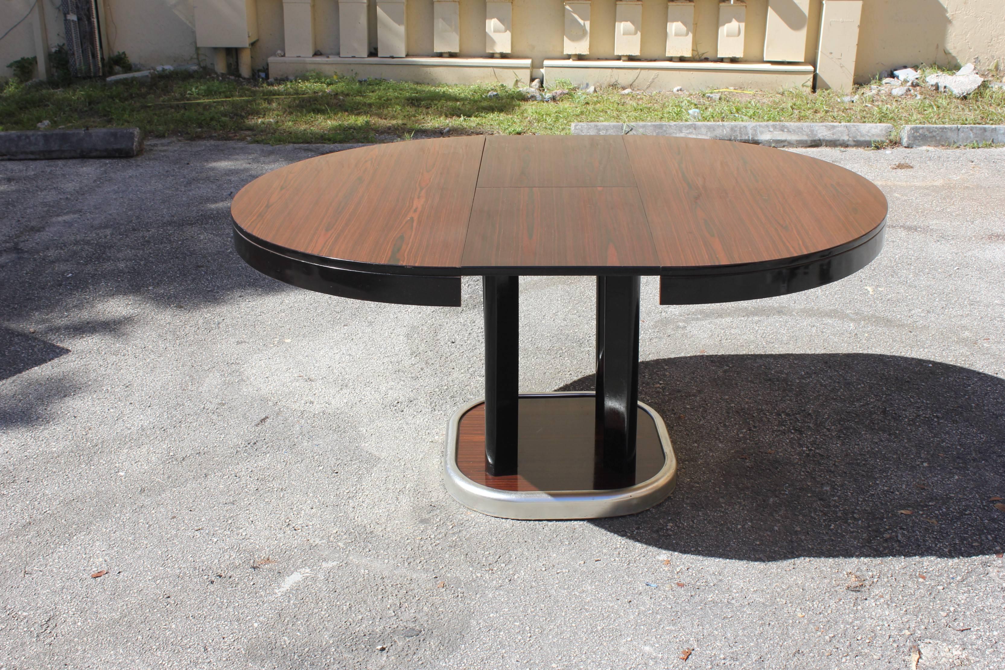French art deco exotic Macassar ebony round dining table with built in extension leaf. Outstanding French art deco or art modern Macassar ebony expandable dining table from the 1940s. Beautiful four legs base. Accommodate, additional leaves. This