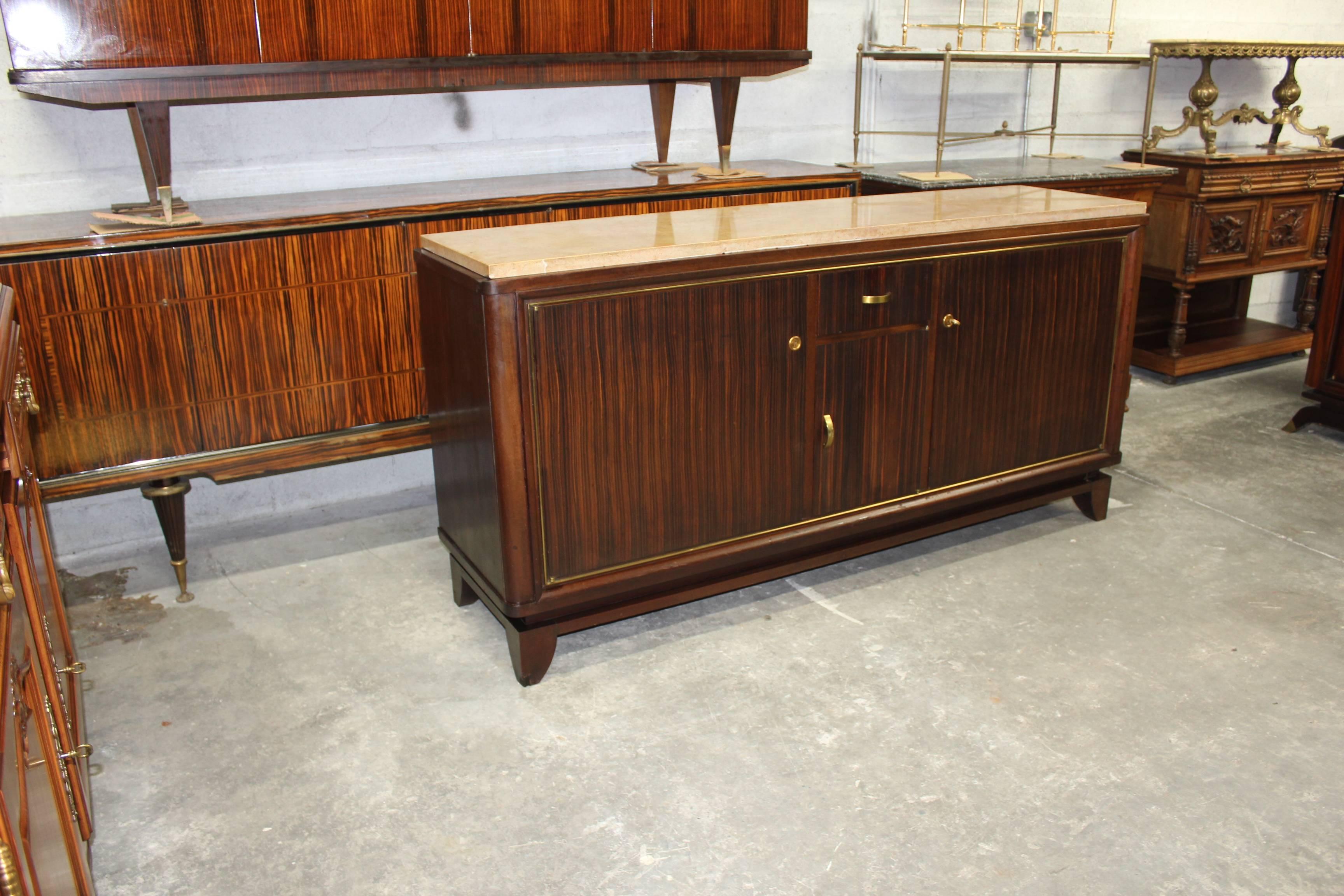 Beautiful French Art Deco Macassar ebony wood sideboard or buffet designed by Maurice Rinck. Mahogany wood interiors, with all adjustable shelf, with three doors one drawer, all with gilt bronze hardware with marble top. Original finish, circa 1940s.