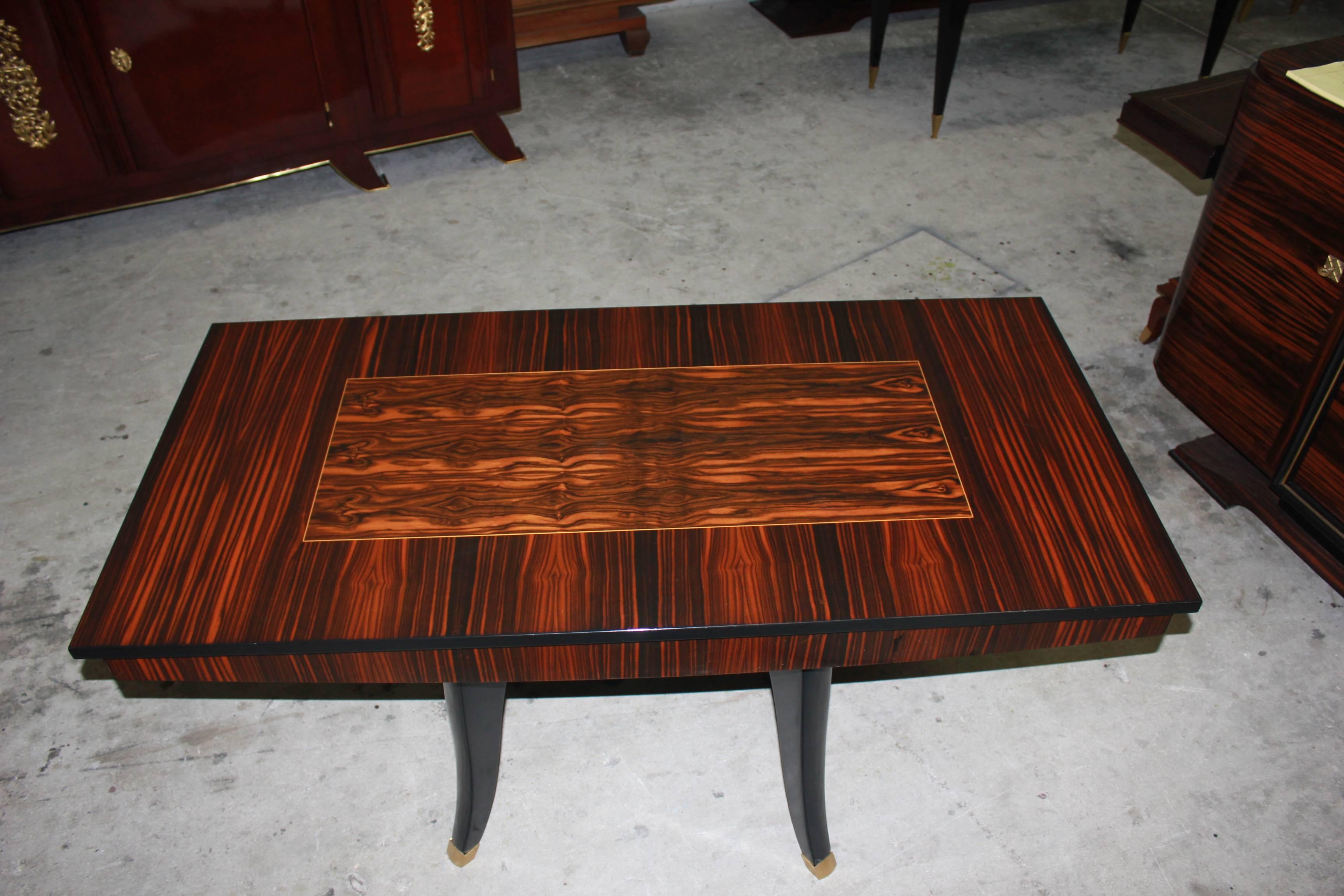 Beautiful French Art Deco exotic Macassar ebony rectangular centre table or dining table, circa 1940s. The table are in perfect condition, four Sabre legs ebony with bronze hardware detail, Macassar ebony top with centre inlay parquetry Macassar,