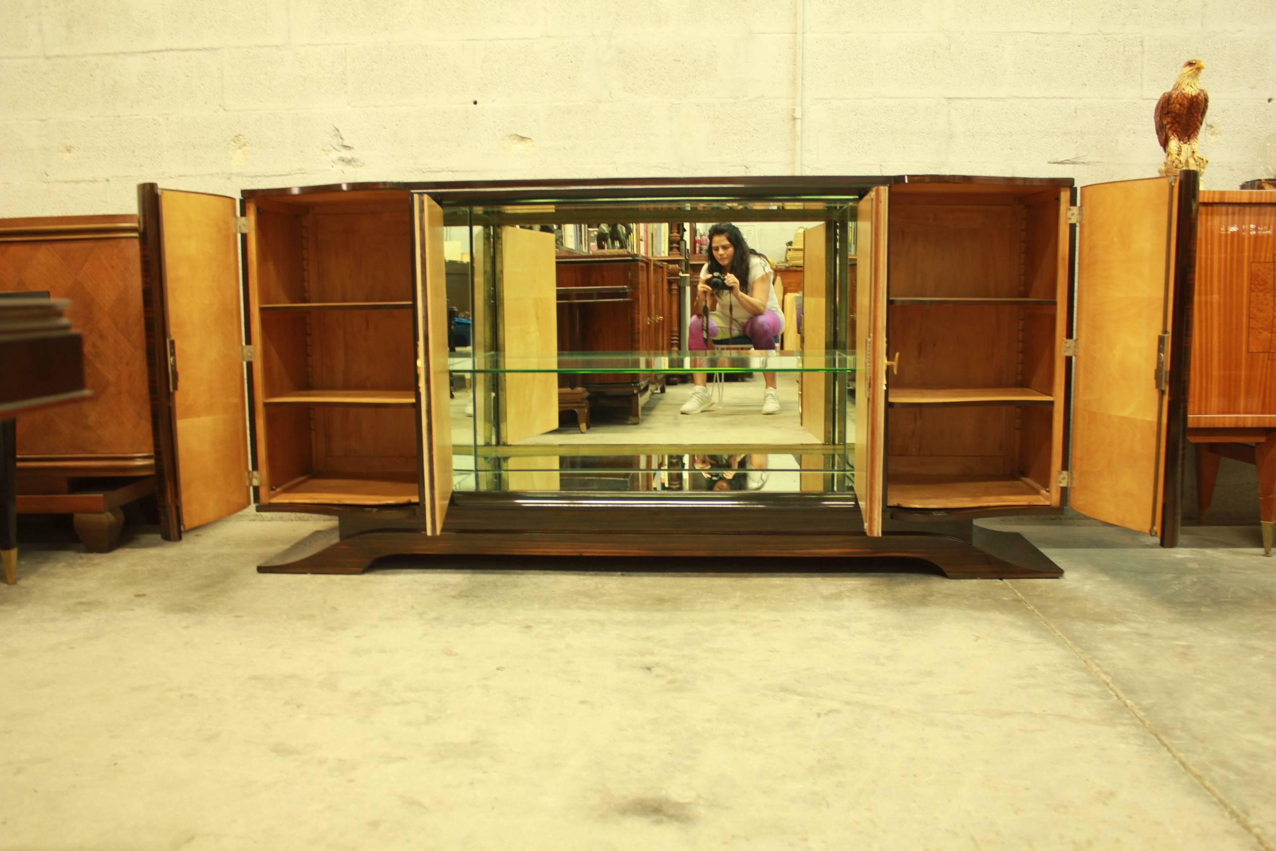 Beautiful masterpiece French Art Deco Macassar ebony, diamond parchment center doors, sideboard or bar designed by Maurice Rinck, completely refinished high gloss. With center bar mirror and shelves glass, sycamore wood interiors, all four wood