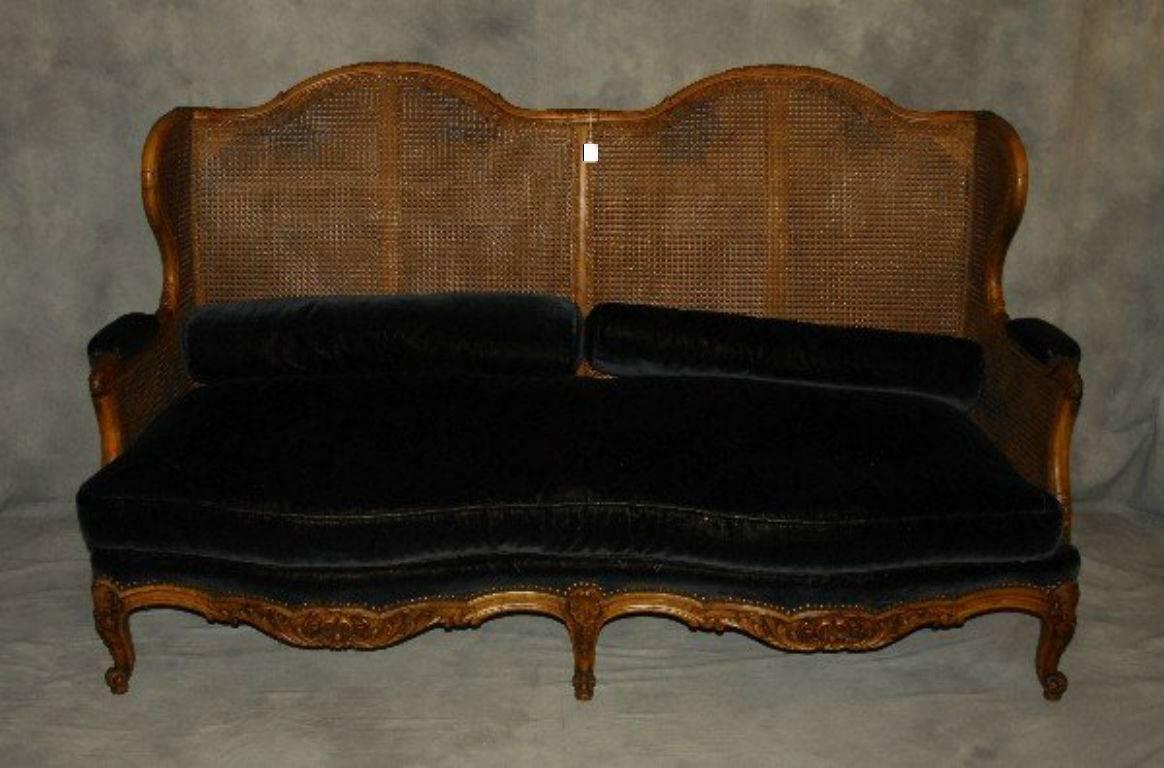 Three-piece Provincial Louis XV carved fruitwood double cane salon set; comprised of a sofa and two generously proportioned bergeres, all upholstered in a dark green mohair fabric. Sofa: H: 42