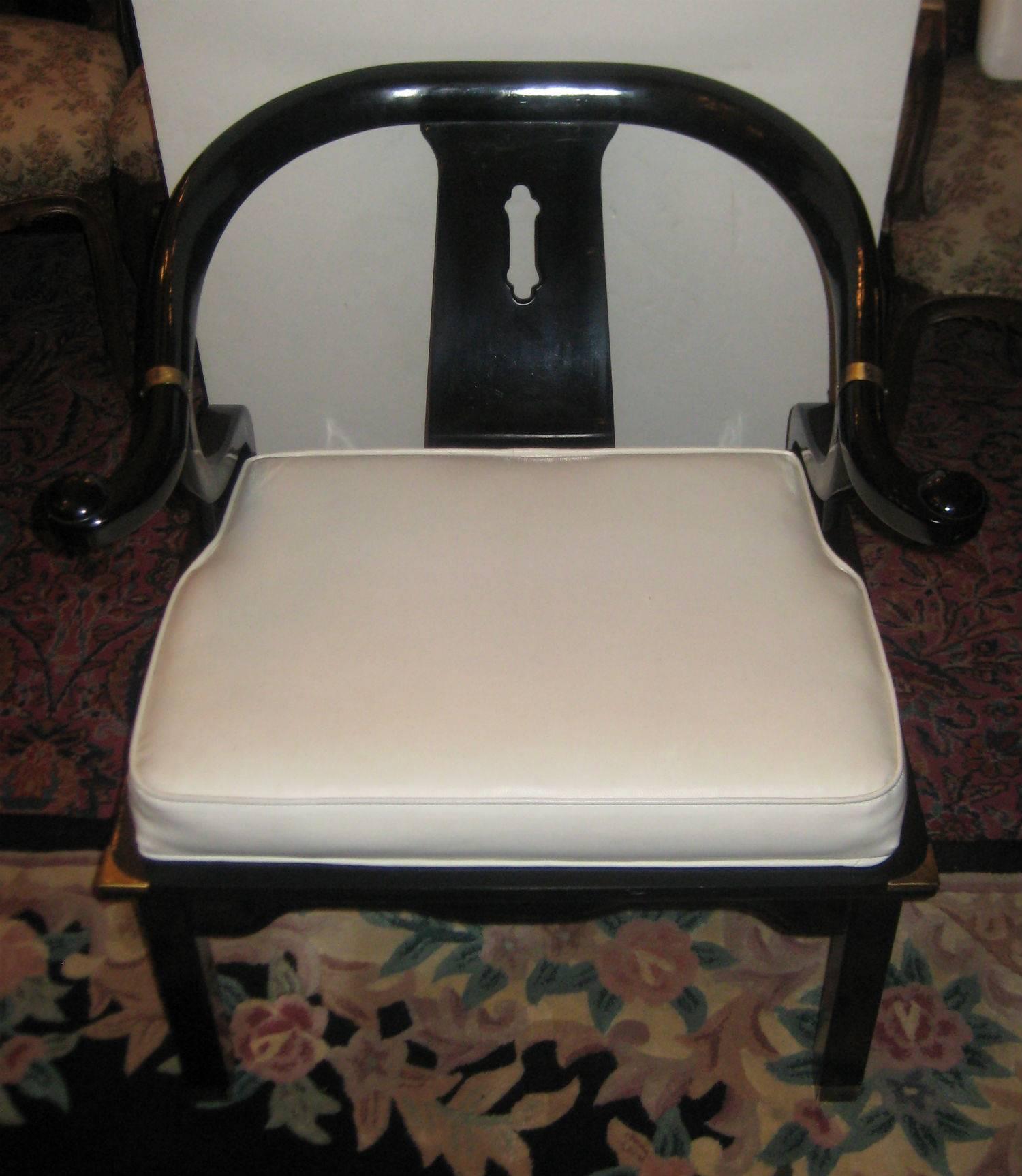 Pair of James Mont style black lacquer horseshoe back chairs and ottoman/table, upholstered in white vinyl; the chairs have a removable back cushion for added seating comfort. Chairs measures: H 29.5