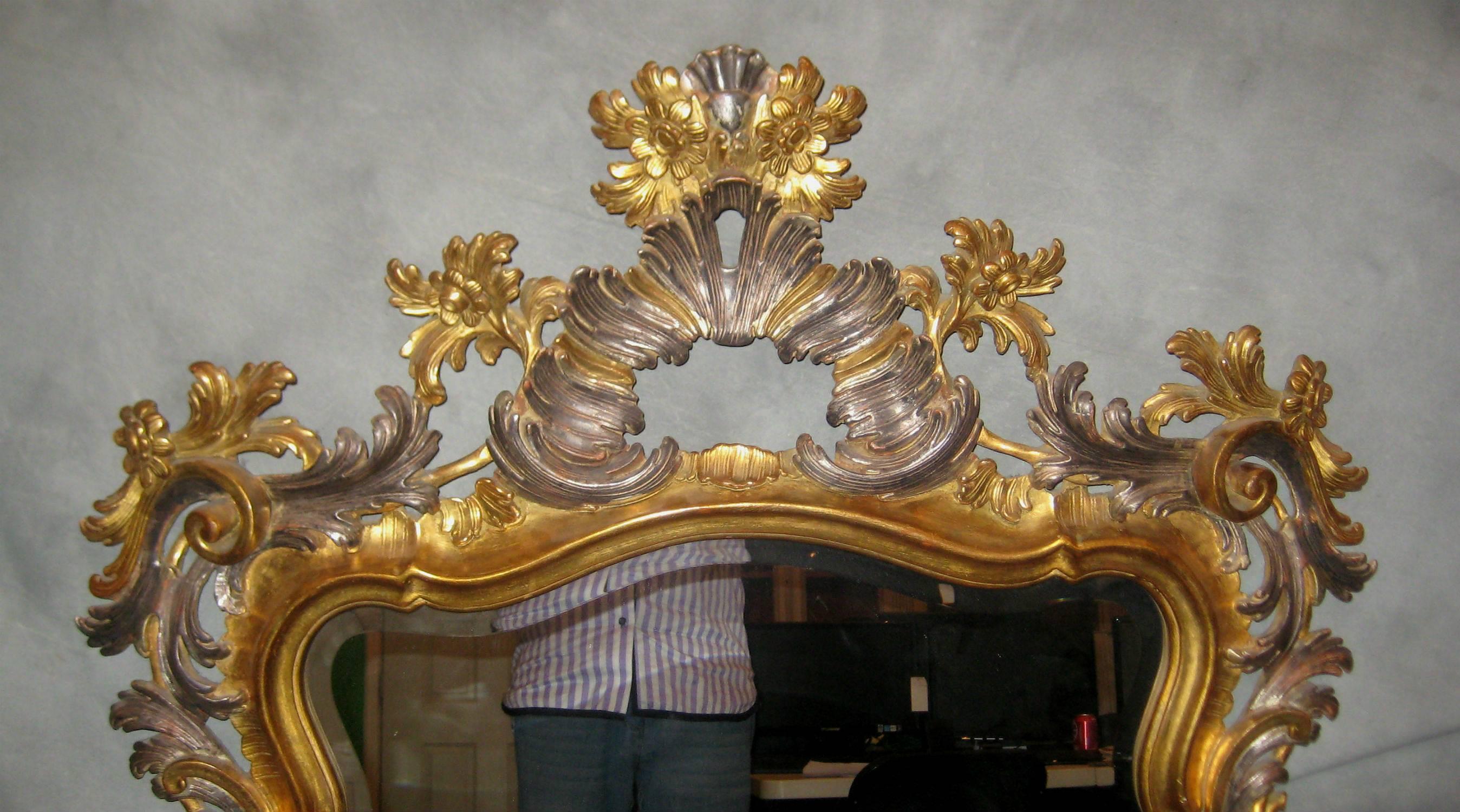 Pair of Rococo style carved gilt-wood and partial silver gilt beveled glass mirrors.

After 43 years of business we are retiring. Everything must be sold. Many of the pieces listed here on 1stdibs represent markdowns below our cost. We thank
