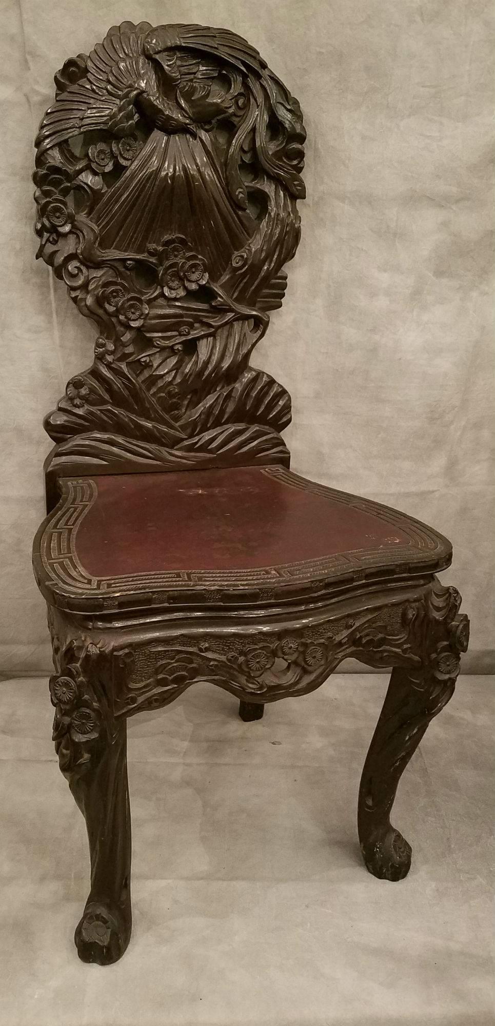 Two Japanese ornately carved hardwood chairs.