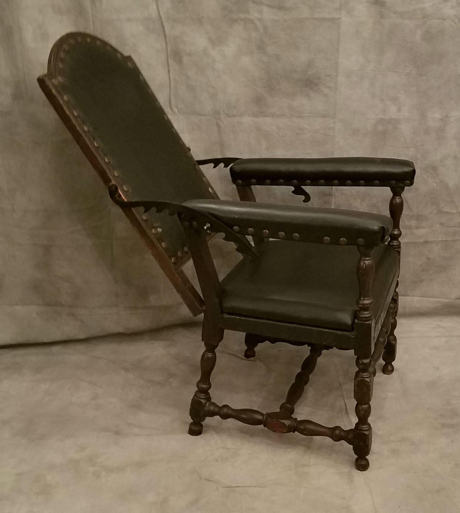 English oak and black leather reclining back chair, peg construction throughout.