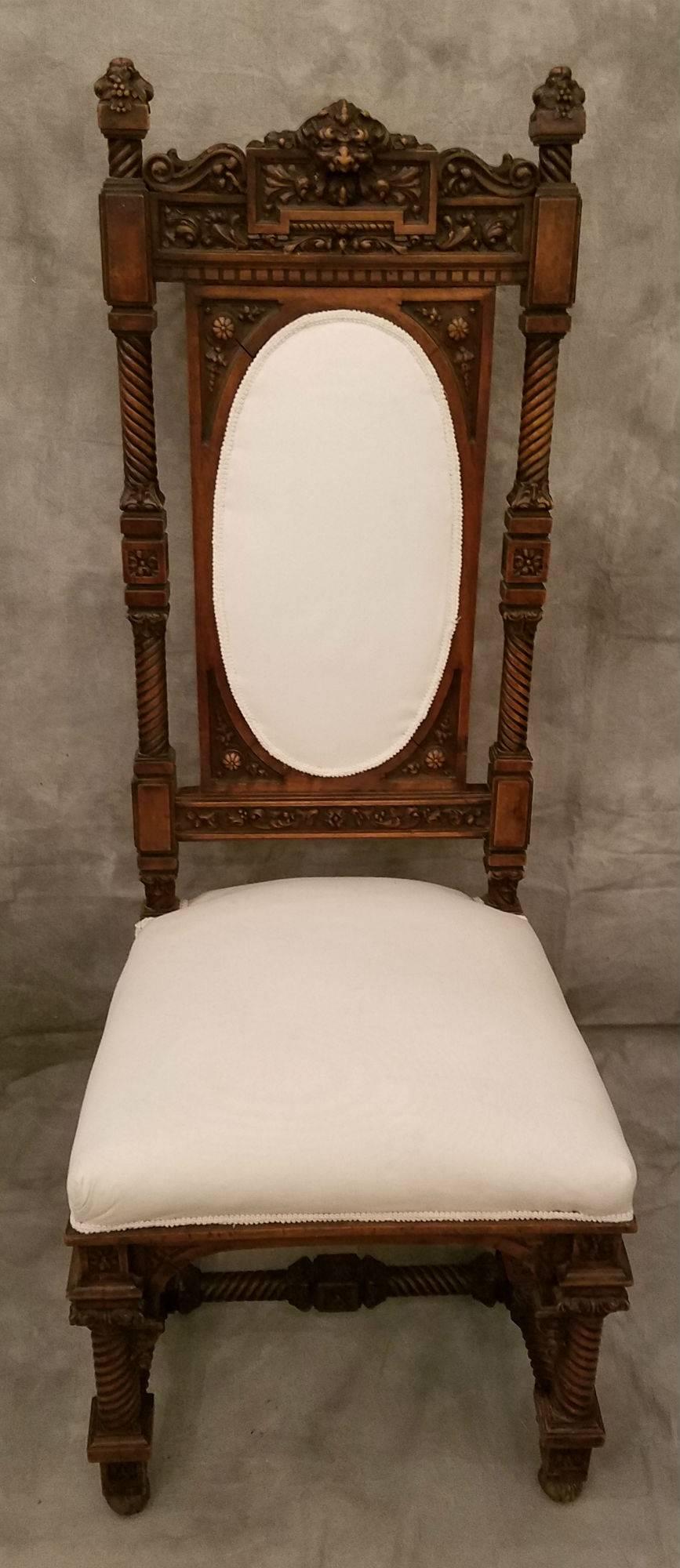 Set of four Renaissance style carved walnut side chairs with bronze front and back feet.  