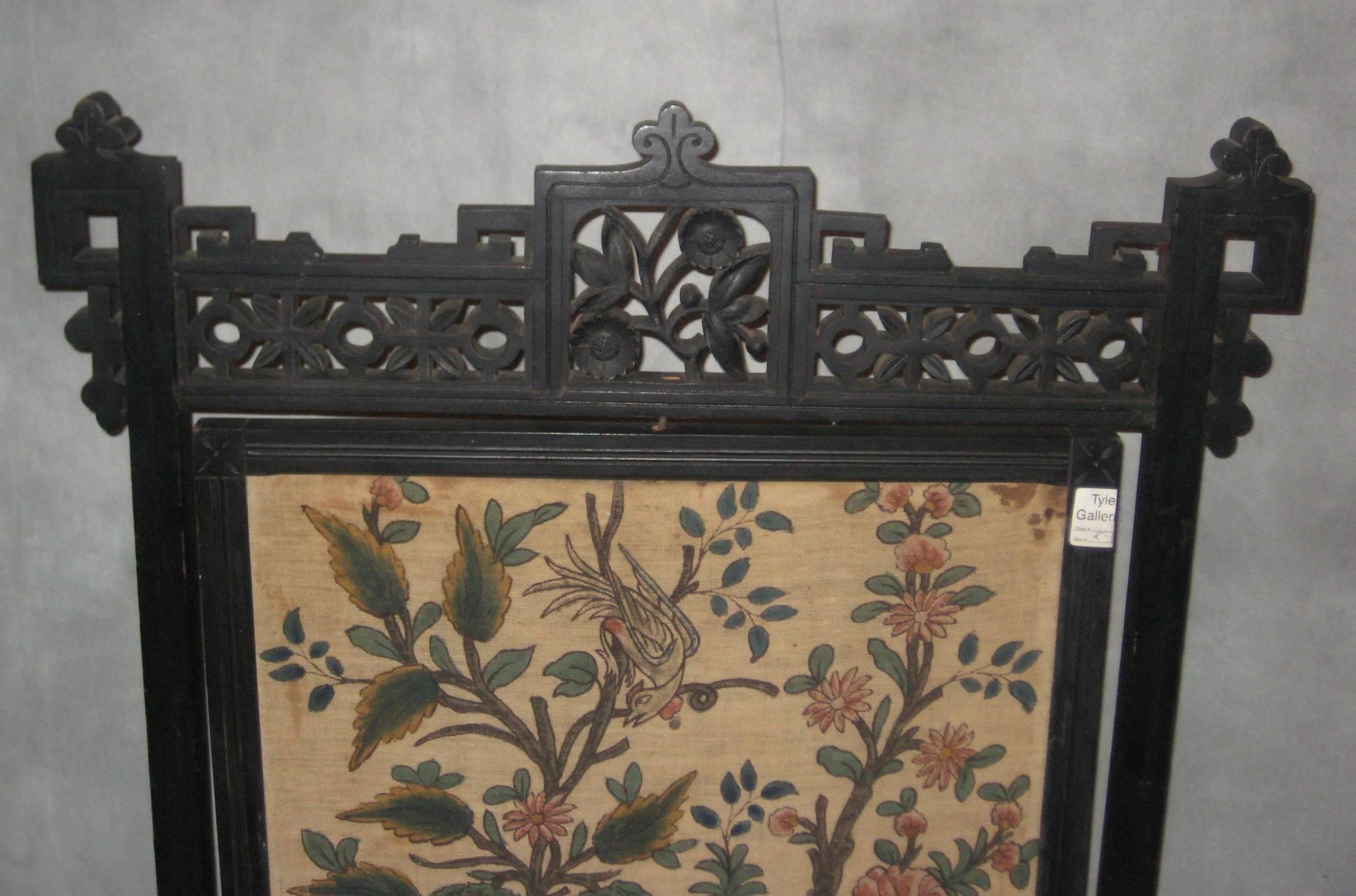 Aesthetic period firescreen in classic Eastlake style, carved black walnut, with dark finish appropriate for the period, pivoting (rotating) batik panel depicting bird and flowers the backside plain. 
