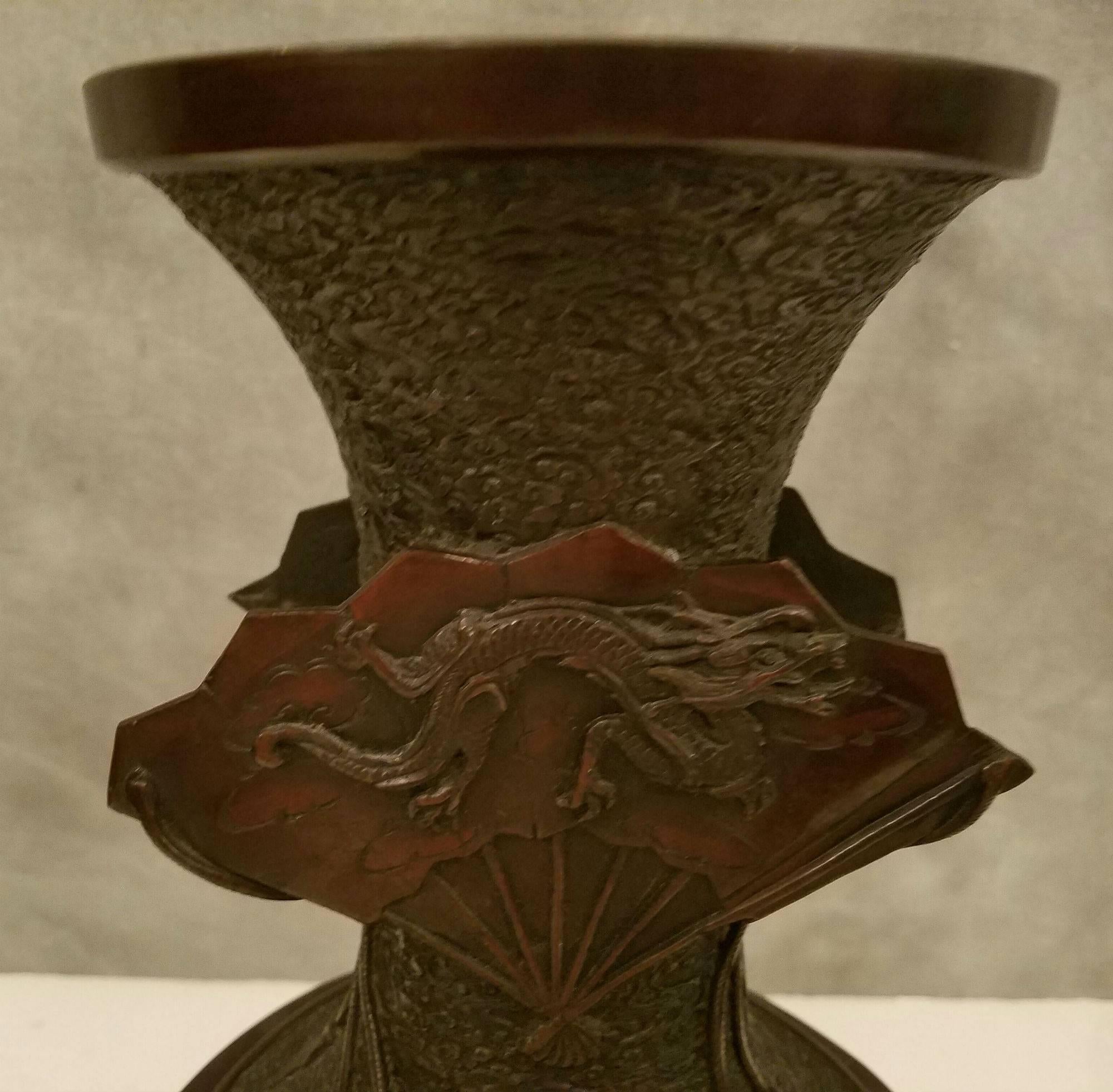 Large Japanese bronze vase, the neck decorated in relief with a fan and dragon the reverse with fan and bird and foliage, the body fans and birds and foliage.
