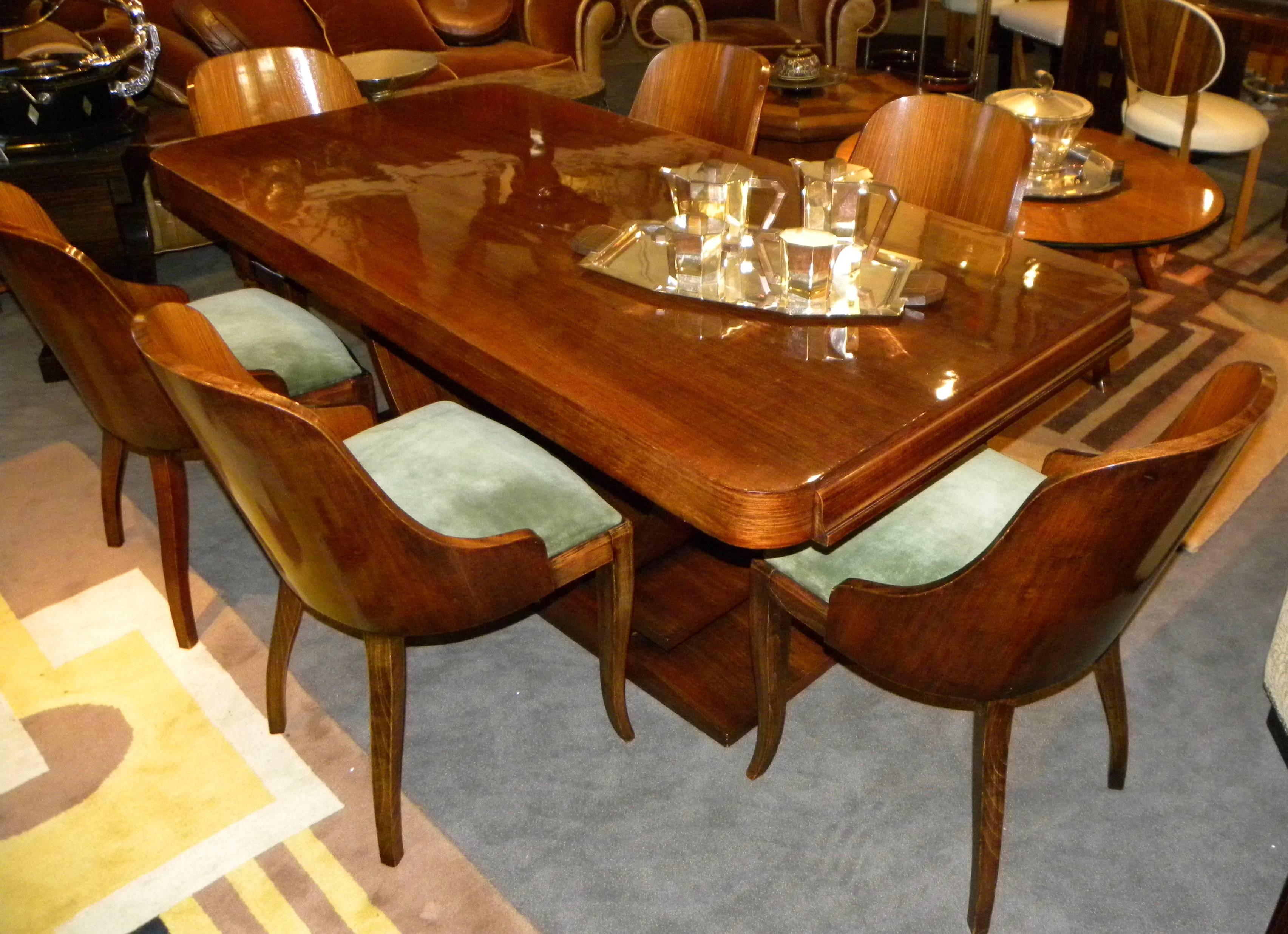 Lush, modernist dining table, gondola chairs and big, beautiful buffet make up this dining suite made in France in the 1930s. Crafted of finest rosewood and finished in gleaming French polish, this grouping will transform your home into the perfect
