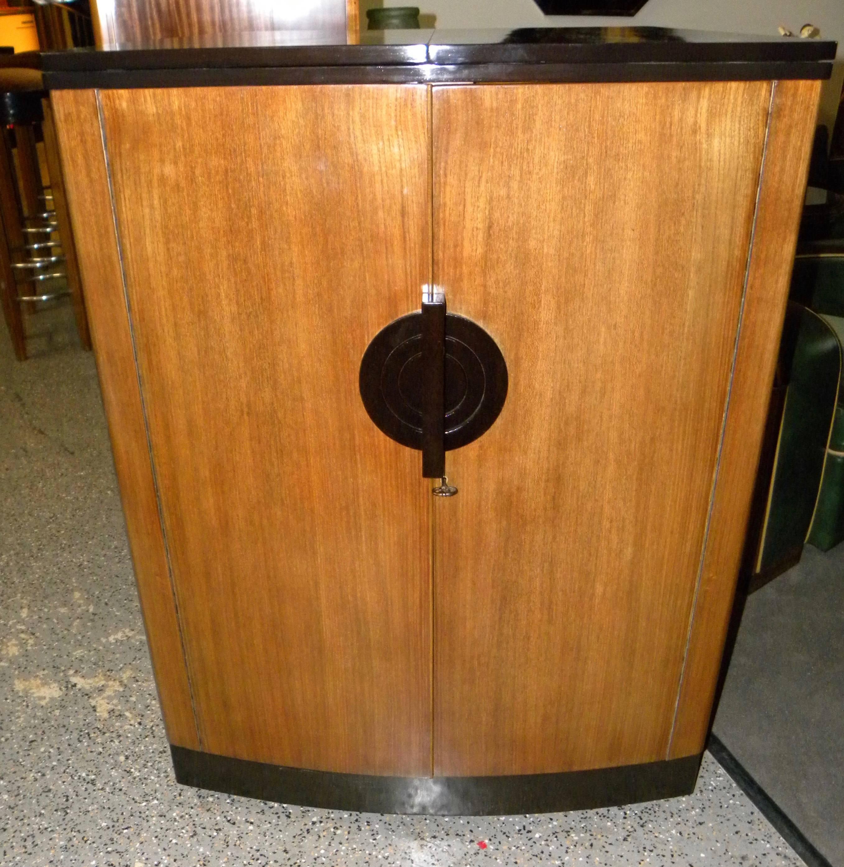 Spectacular English Art Deco envelope bar with flawless two tone flamed maple and mahogany wood finish can be opened as a half round “stand behind bar” or cabinet, discreetly closed to become quite compact! These clever designs, originally used on