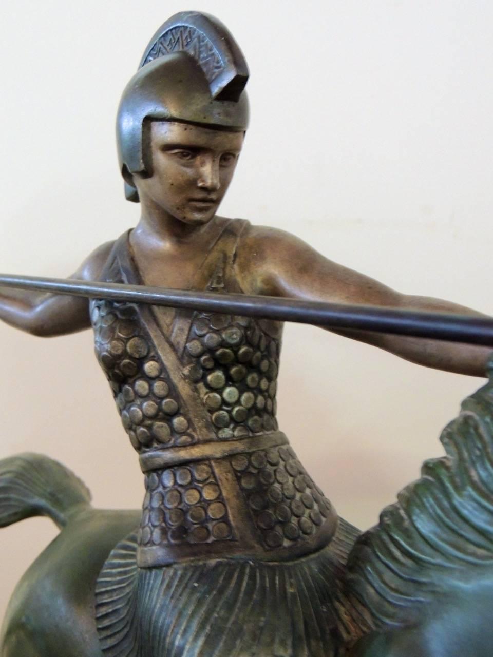 Une sculpture Art Déco magnifiquement exécutée d'une femme guerrière en métal peint à froid avec une base verte richement patinée et des touches de dorure. La pièce est signée par Melo:: un sculpteur connu pour ses thèmes équestres dans son art et