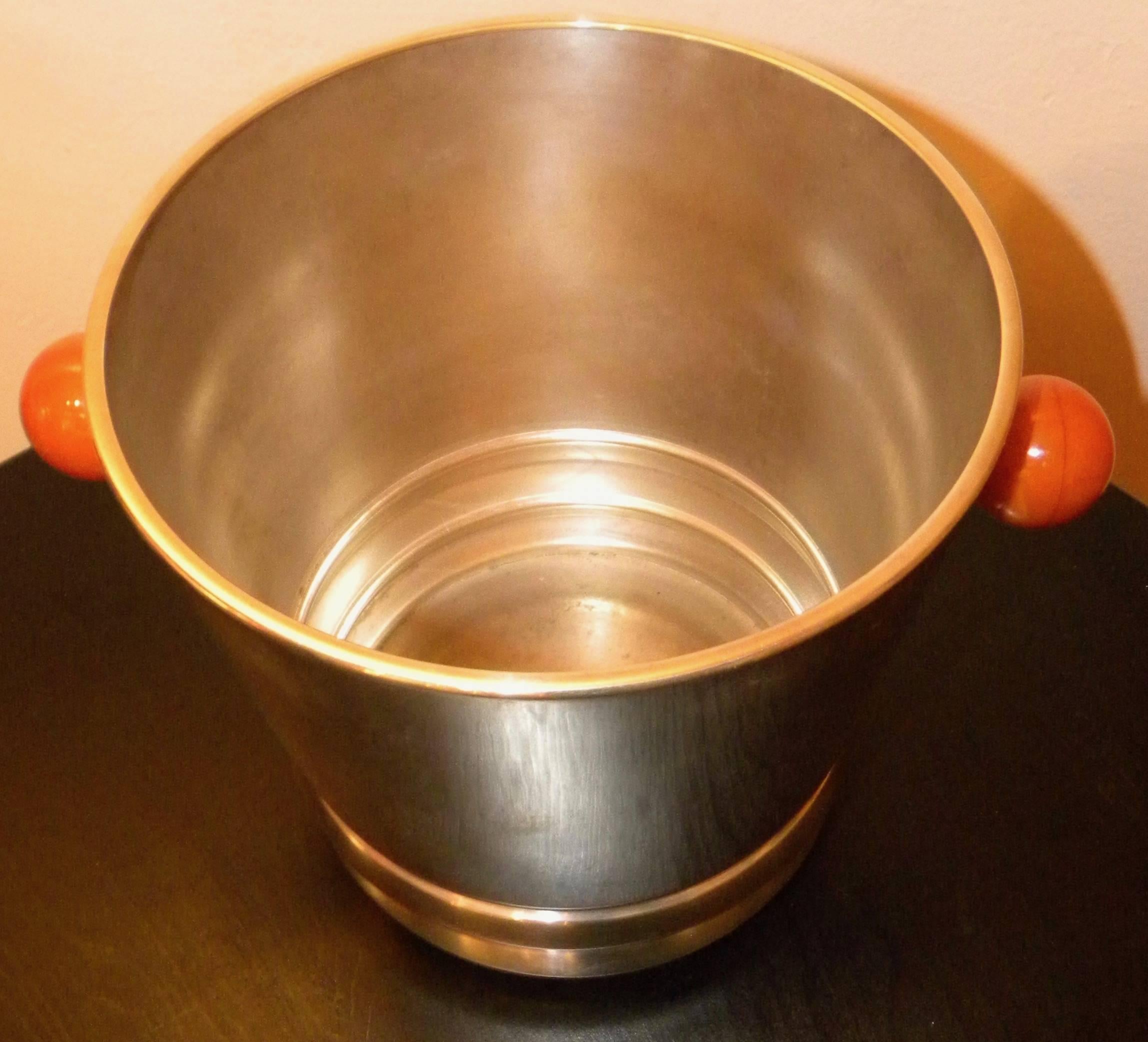 An Art Deco champagne cooler/ice bucket in heavy silver plate by Quist has a wonderful modernist style. The detachable Bakelite handles make a wonderfully decorative addition to the sleek design as does the stepped bottom of the piece. In excellent