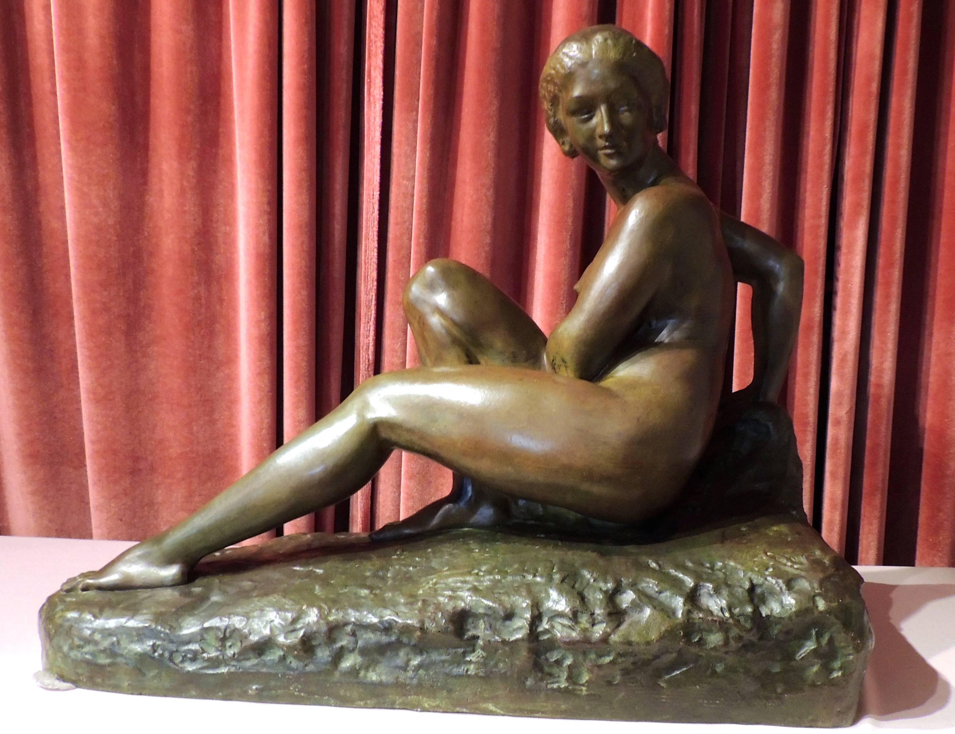 An Art Deco sculpture as substantial as it is beautiful, this work is a bronze statue by Marcel Bouraine. A seated nude in a demure pose, it has acquired a rich patina. The base is an integral part of the piece, also cast in bronze and bearing his
