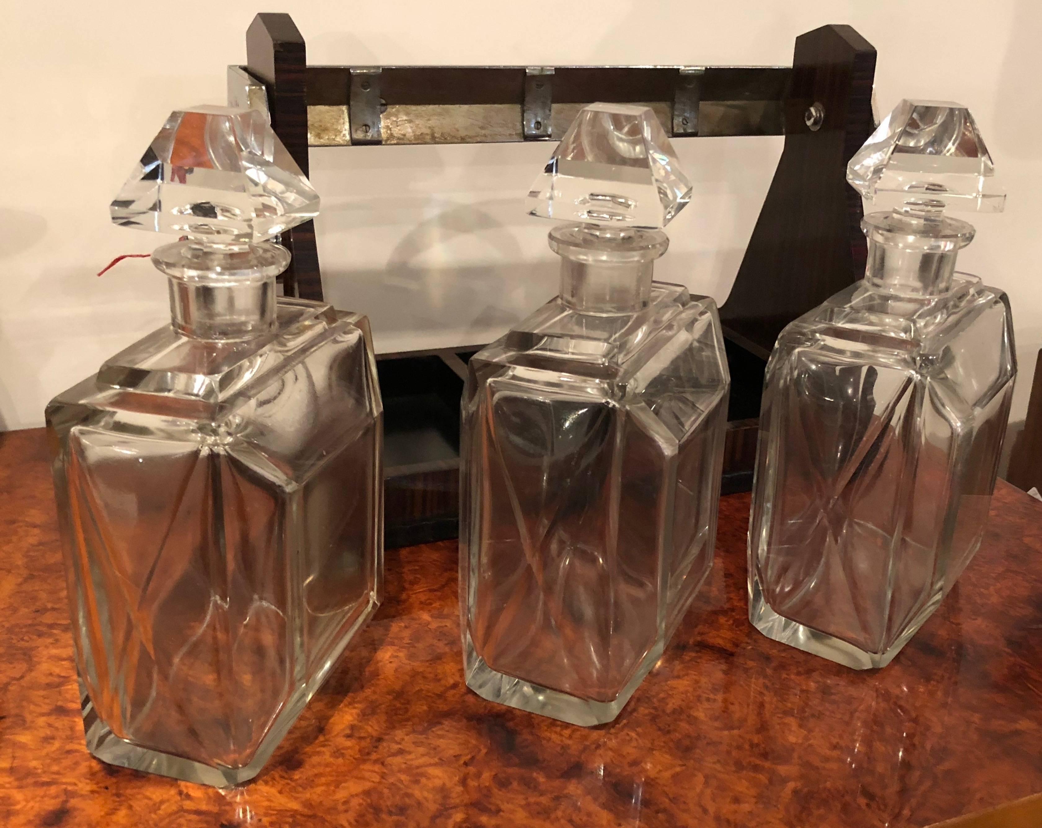 Silver-mounted Macassar tantalus, with a patent mark of George Betjemann & Sons, London circa 1925-1930. A unique set with a very modernist approach, stunning cut crystal decanters with matching tops, all in excellent original condition. The company