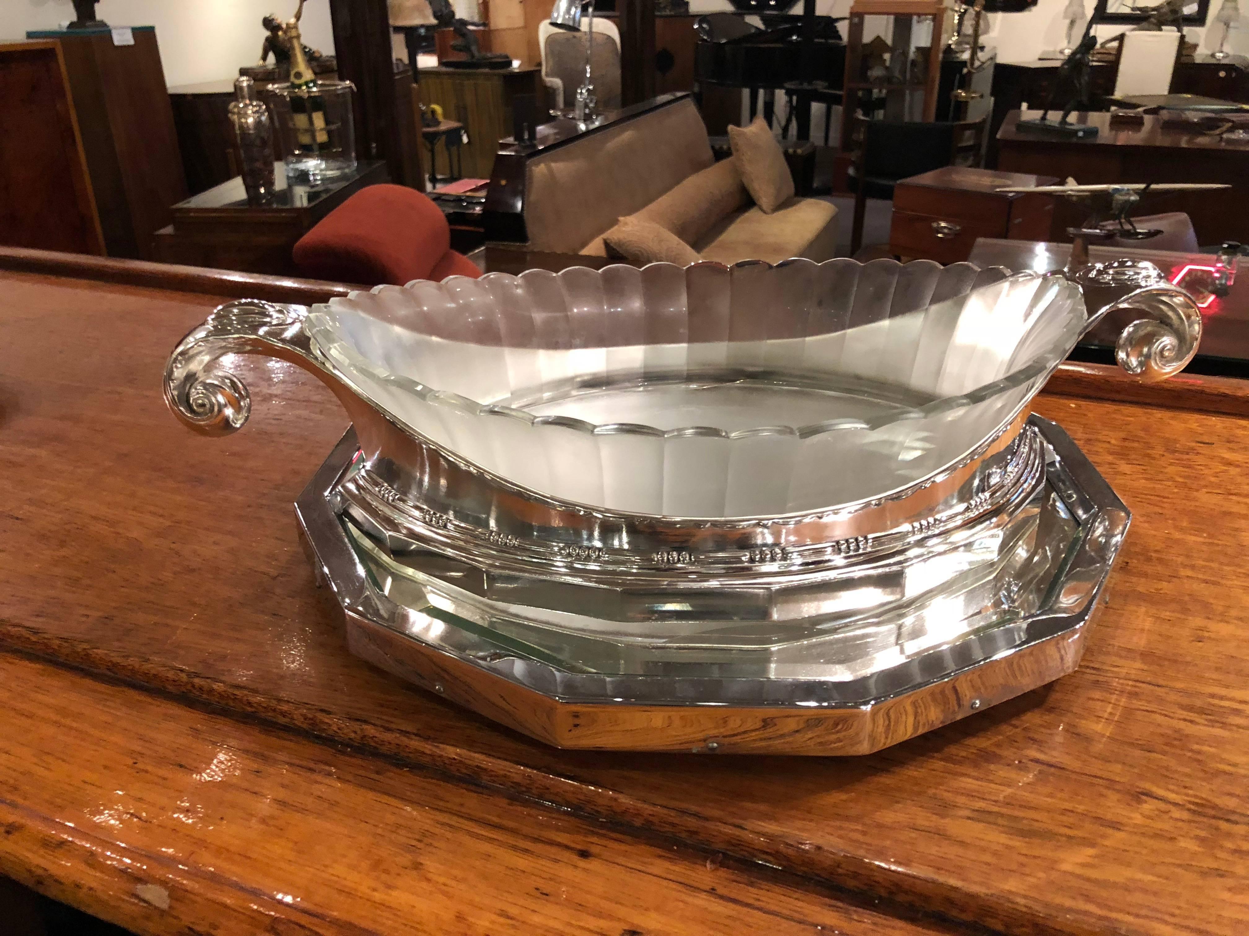 Christofle ‘Gallia’ metal and glass centrepiece designed by Sue et Mare, circa 1930. Faceted thick cut-glass original liner supported within silvered metal mounts with scrolling handles and faceted base. Stamped Gallia Christofle marks, numbered