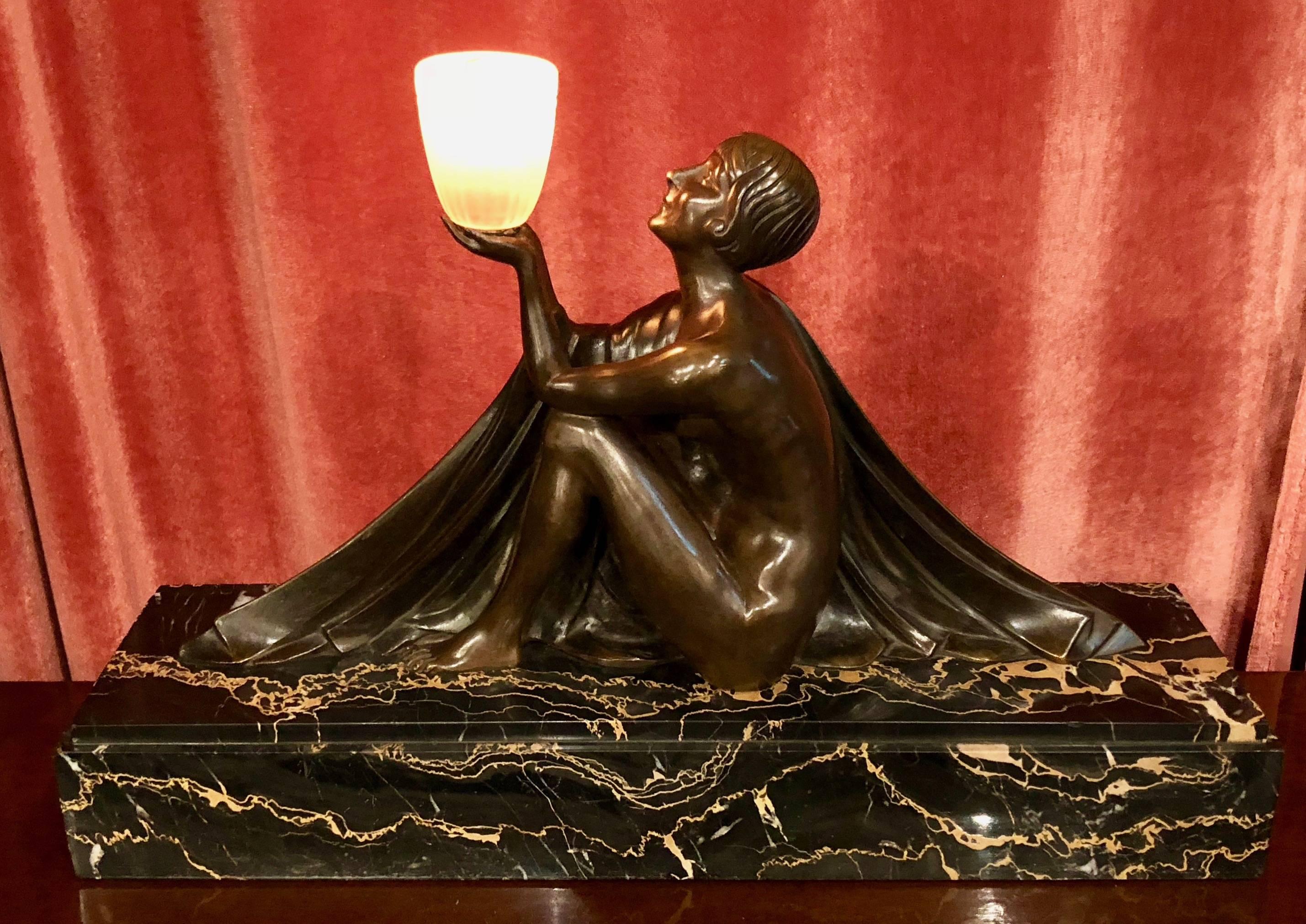 A French Art Deco bronze depicting stylized Art Deco nude woman holding a frosted globe. Cold patinated finish in excellent condition executed by J. Lormier, circa 1930. Stunning double thick portoro marble base in pristine condition. Glamorous