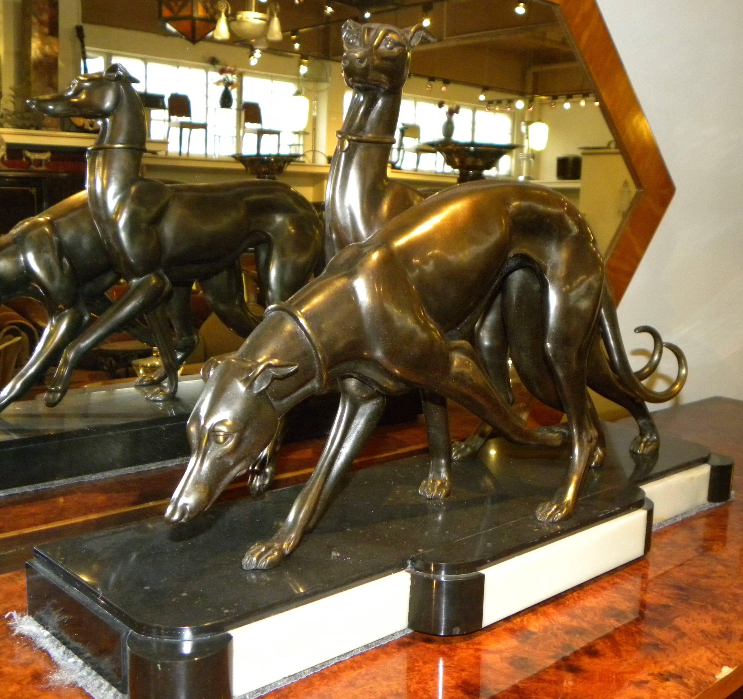 Elegant and regal Greyhound Dogs are the subject of this Art Deco bronze sculpture by Irenee Rochard. The two dogs are in contrasting poses, one standing tall with ears erect and the other in the sharply hunched position of a racing or hunting dog.